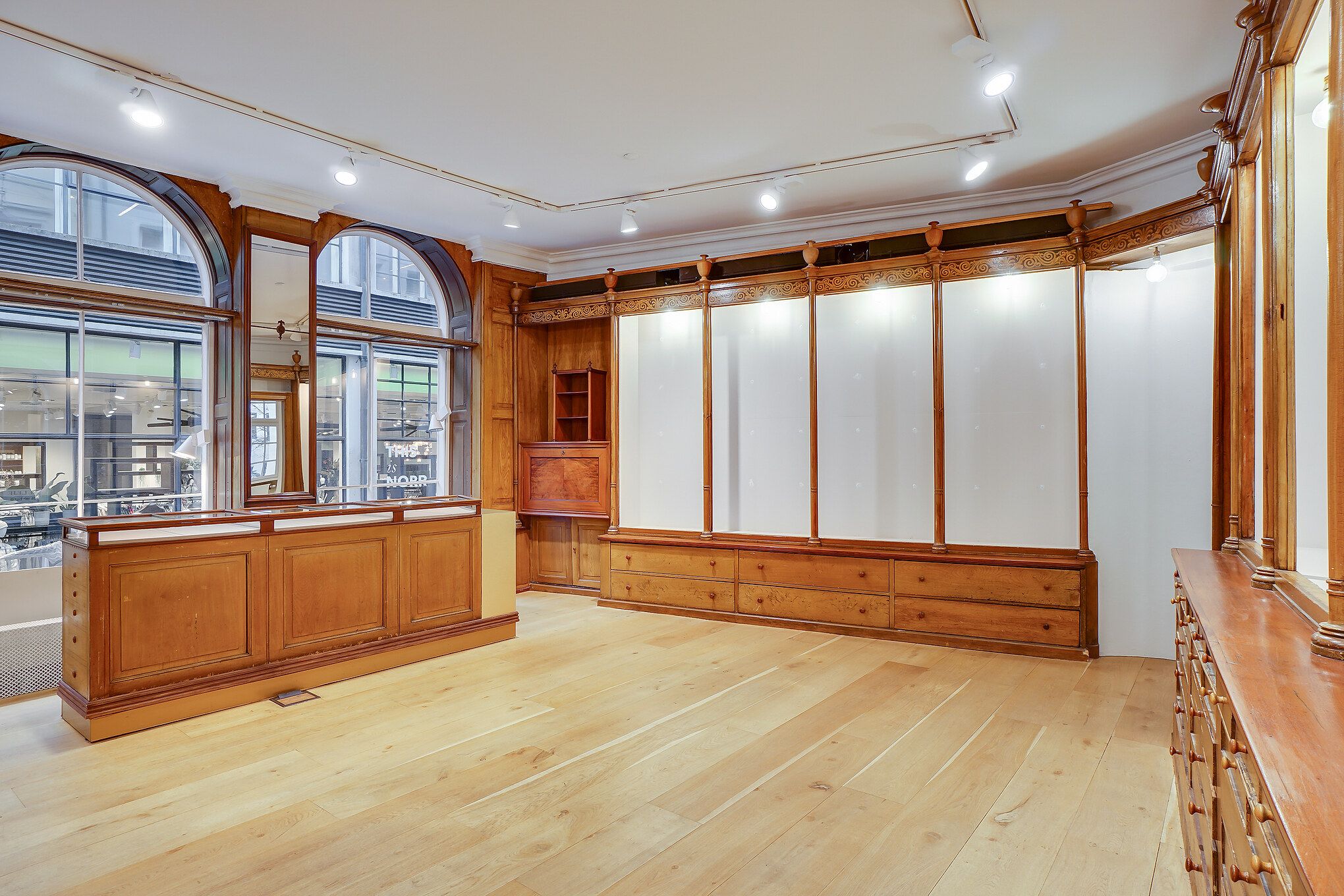 En stor, elegant og moderne restaurant med lyse gulve, høje vinduer og møbler i lyse bøgetræ.