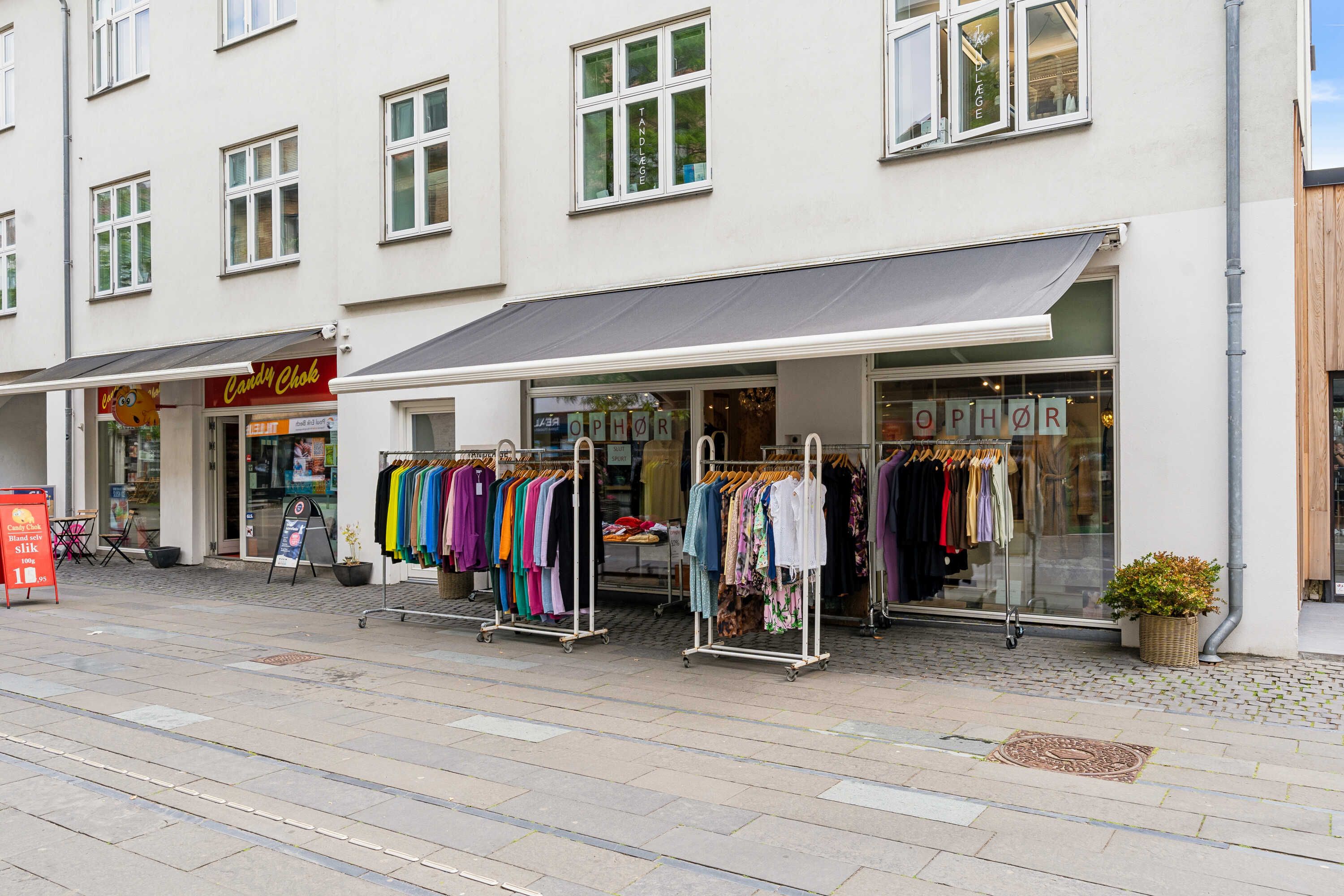 Butik med tøj på udstilling samt opforhor og candy choklad butik på siderne.