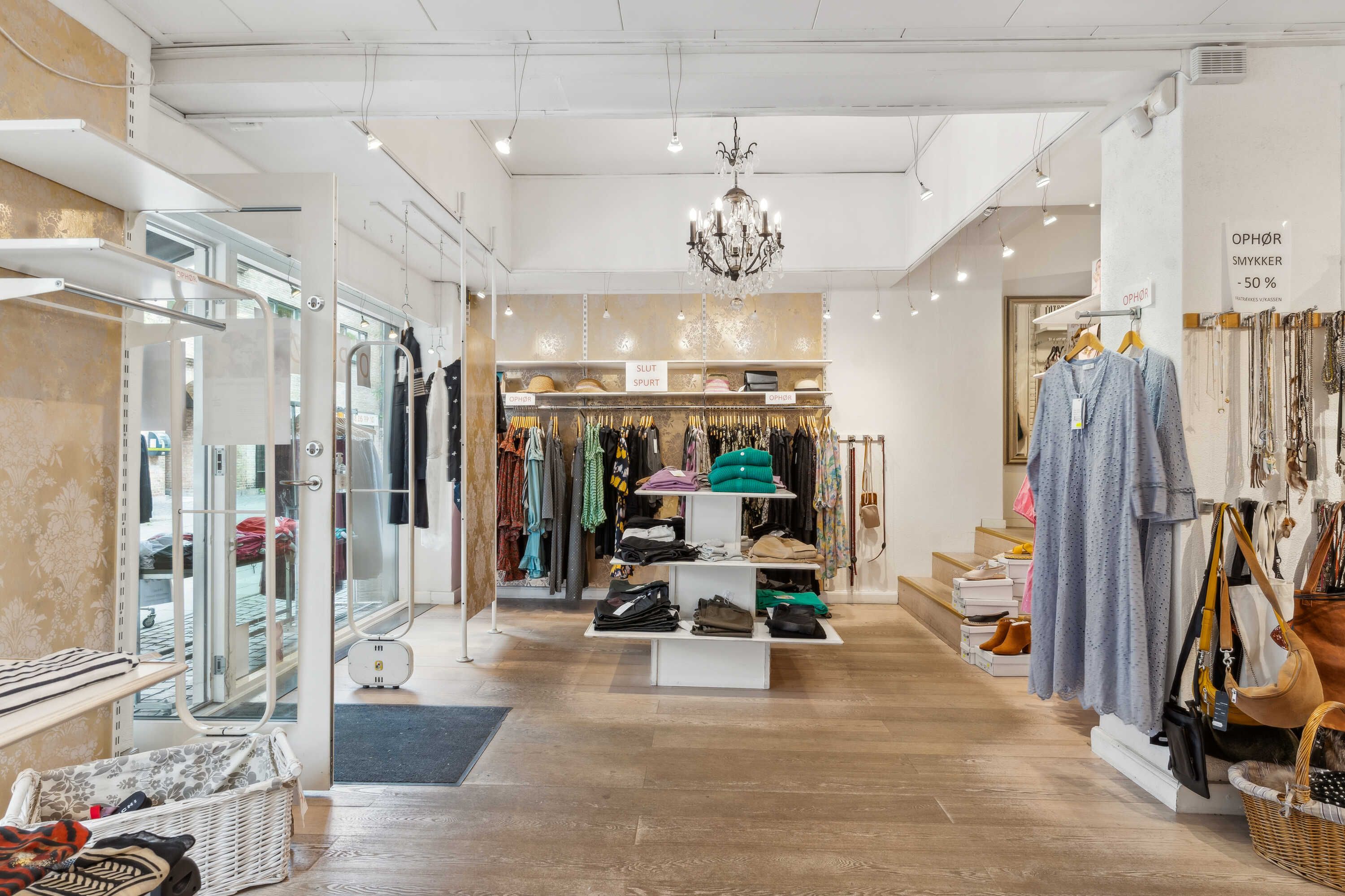 Butik med klæder og tilbehør samt opholdsområder med store vinduer og indvendige lysekroner