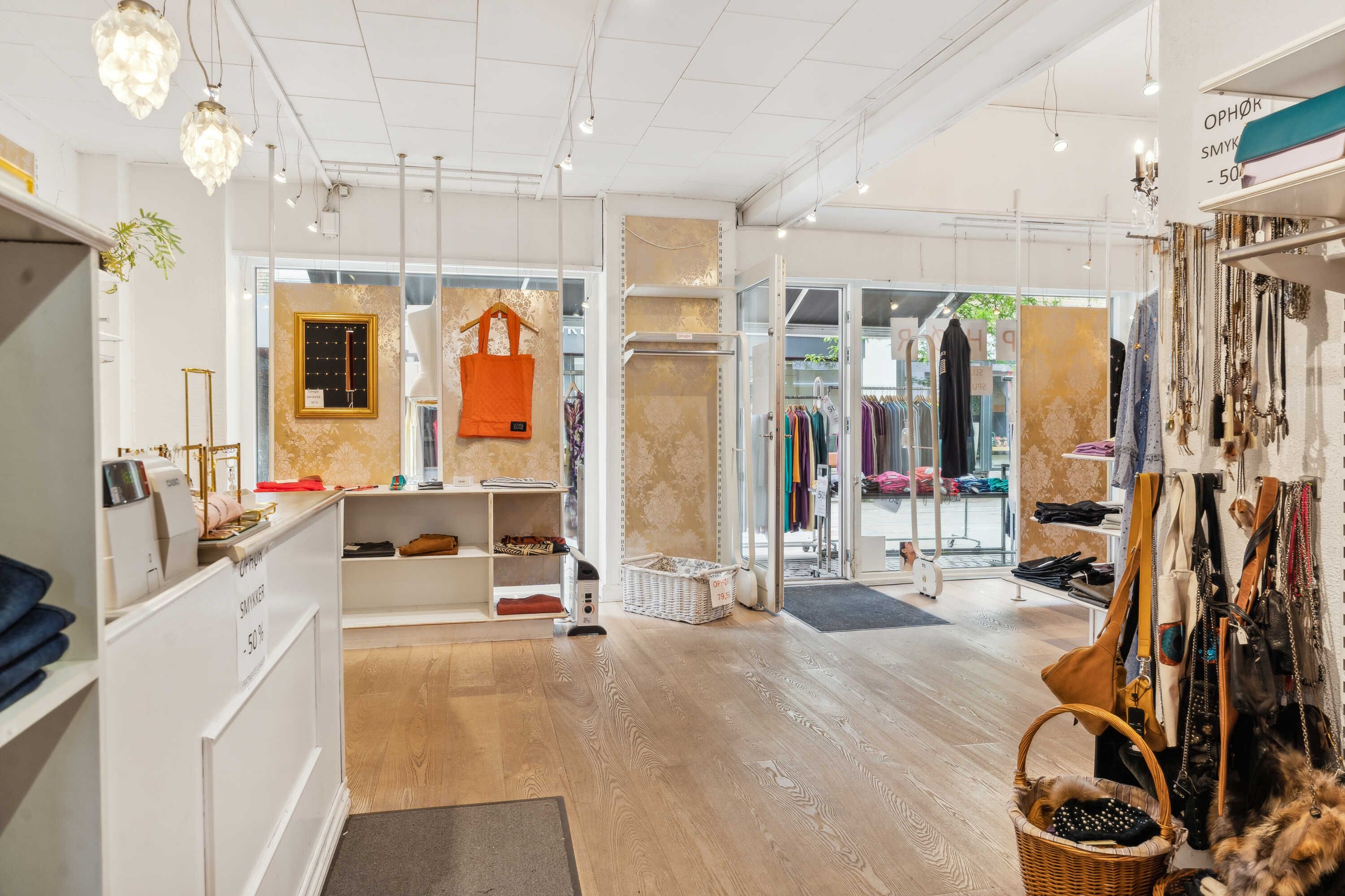 En boutique med hyggeligt indretning og smukke møbler og tøj med mange tilbehør og smykker