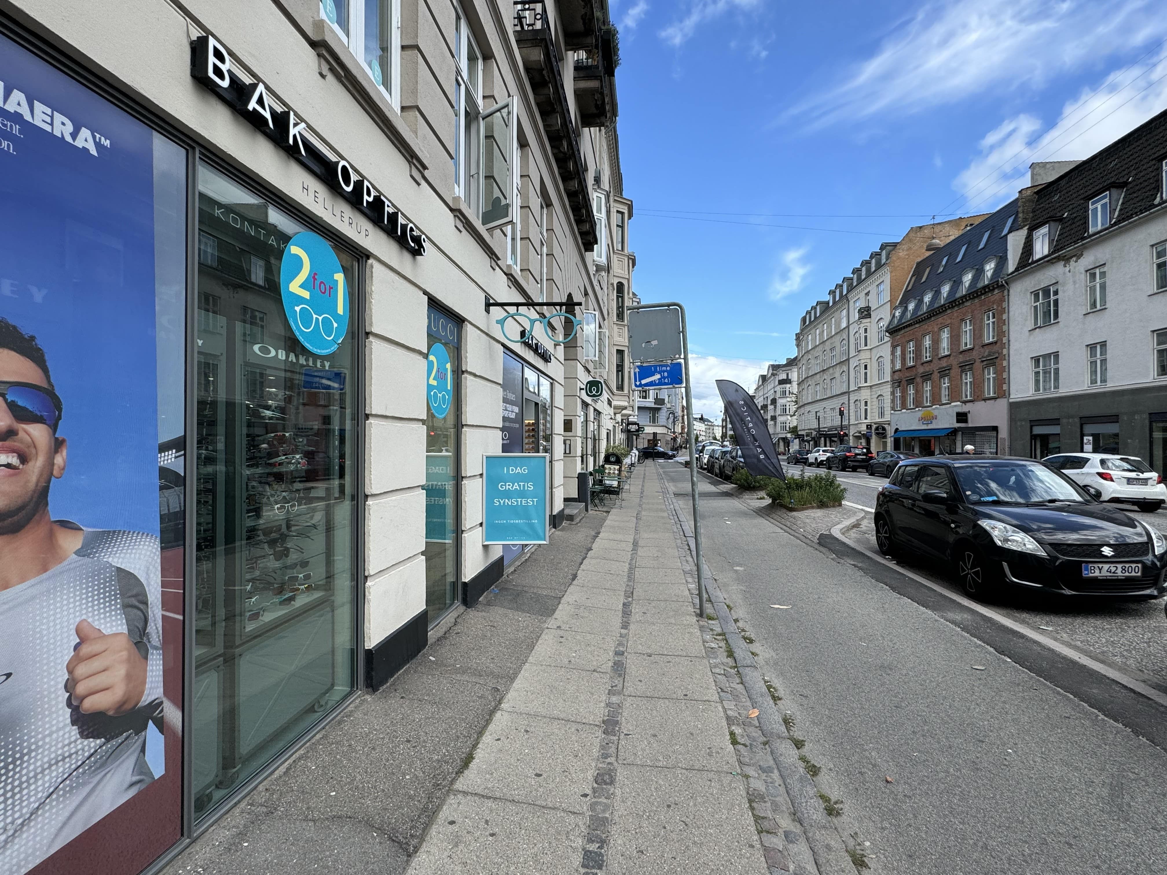 Store butiksvinduer med solbriller og mænd i solbriller og Oakley briller. Butikken hedder Bakoptics og er på Strandvejen.