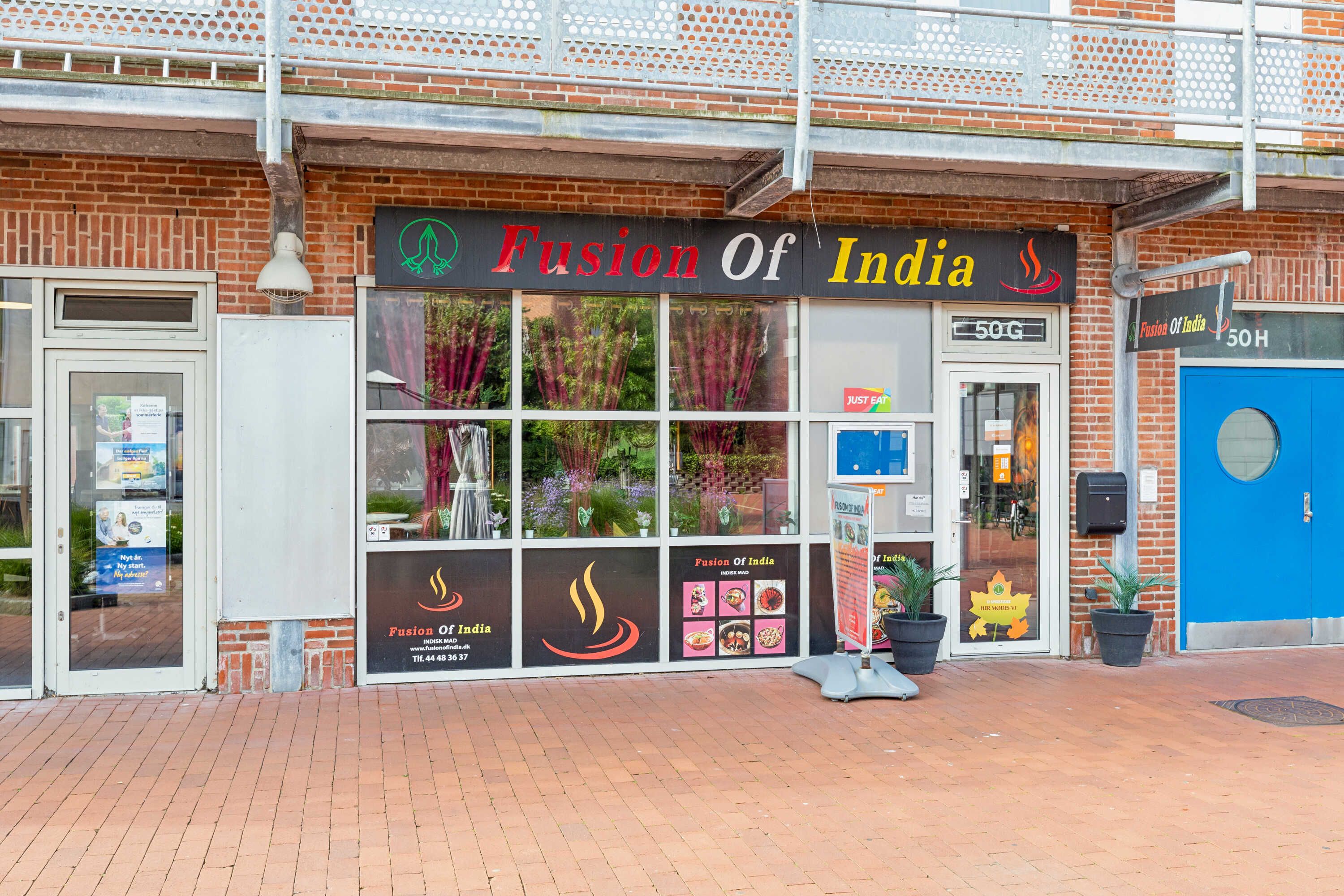 Fusion of India restaurant i Værløse Bymidte med grønne planter, køkkenvinduer og skrifttræk Fusion of India