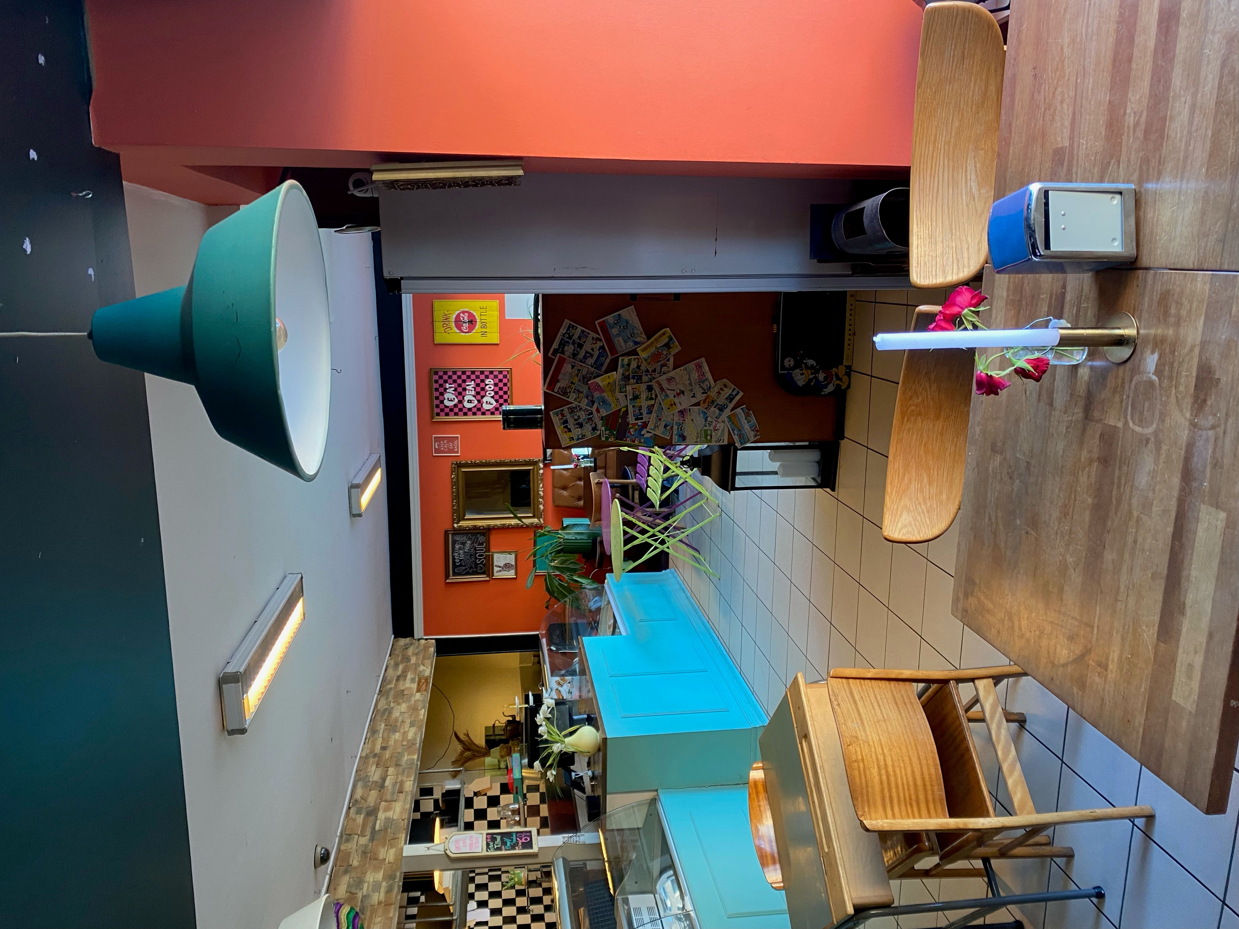 Ny renoveret restaurant med røde og hvide vægge og lyse lamper samt træstole og træborde