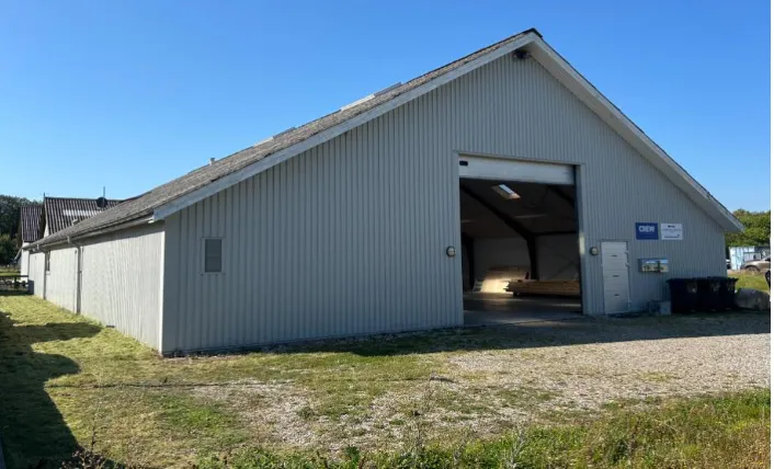 Hal i Engholmvej 19 i Hornbæk med garagedør og vinduer med skilte med teksten Crew