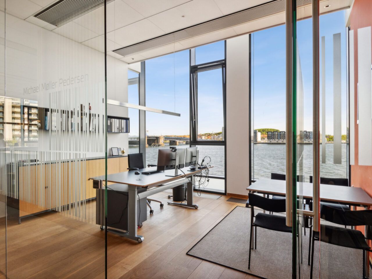 Kontor med moderne interiør, møbler, skrivebord, computere og udsigter til havnen i København