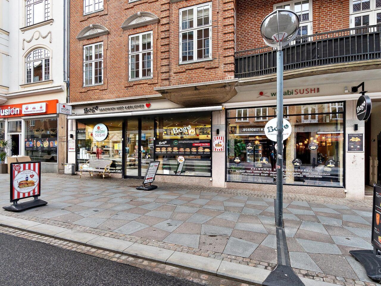 Gade med restauranter og caféer, herunder en sushirestaurant og en hamburgerrestaurant, på Østerågade i Aalborg Centrum