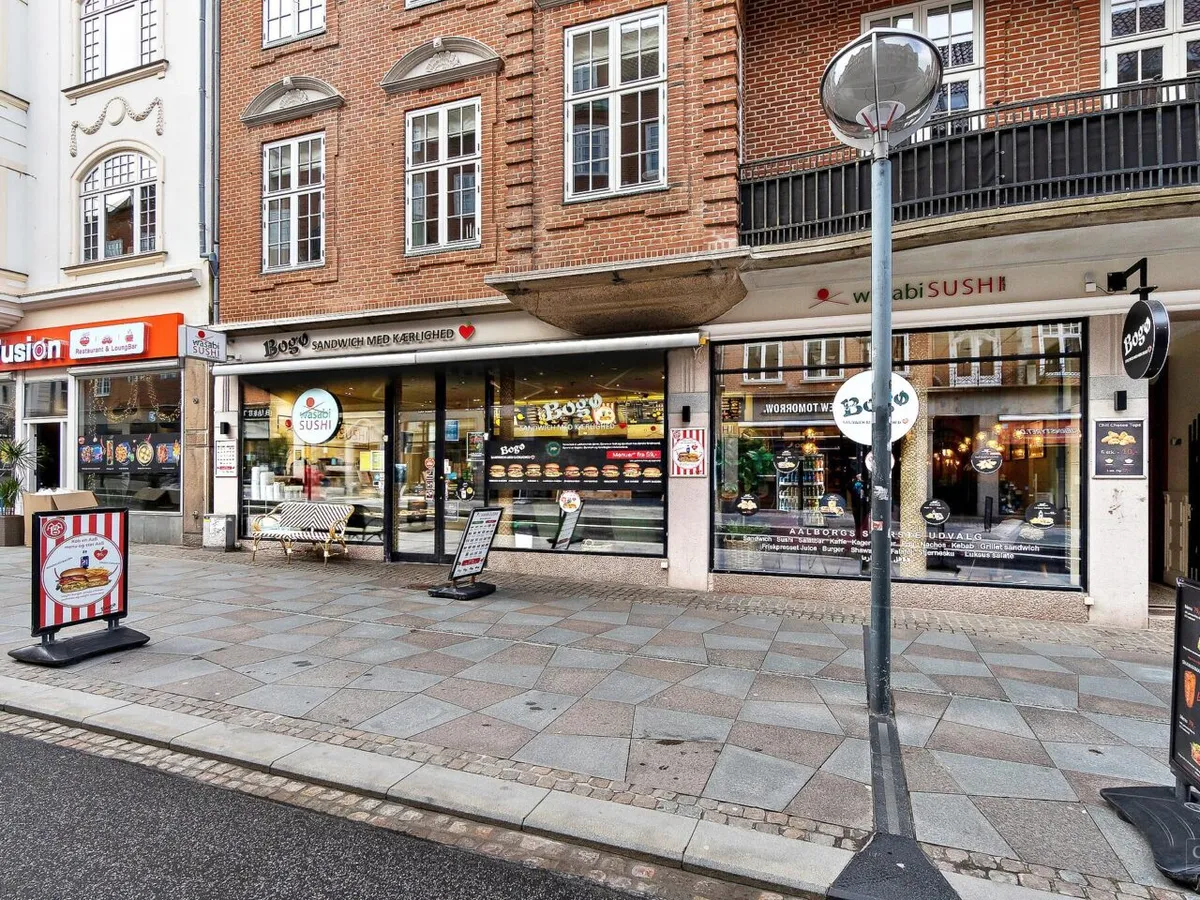 Gade med restauranter og caféer, herunder en sushirestaurant og en hamburgerrestaurant, på Østerågade i Aalborg Centrum