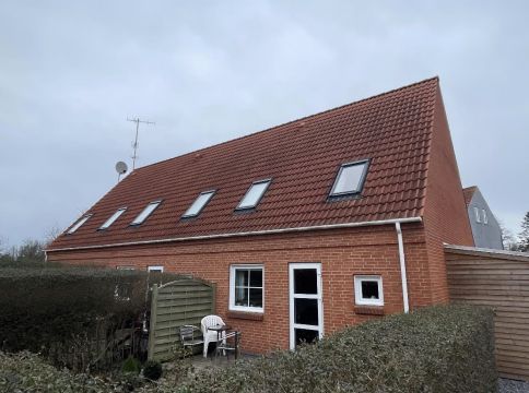 Lejlighedsejendommen med røde tegl er bygget i 2004 og har skur og altan. Havet er blot et stykke fra huset.