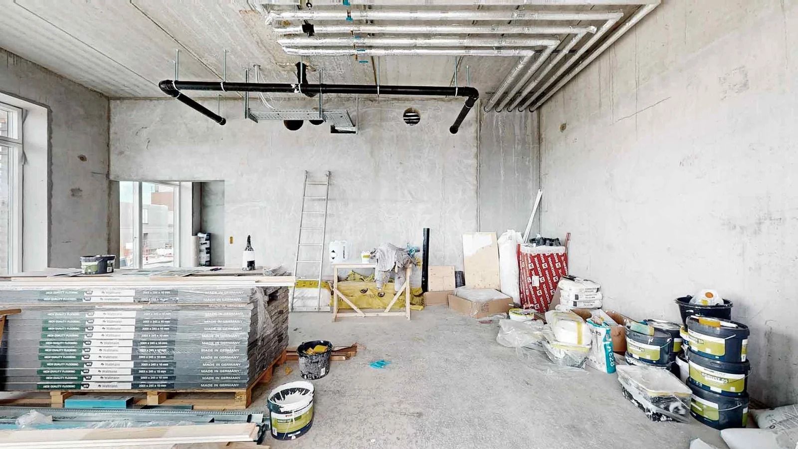 En under opførelse værelse med råværker, tømmer, materialer, lader, stige, malerisprøjter og emballage