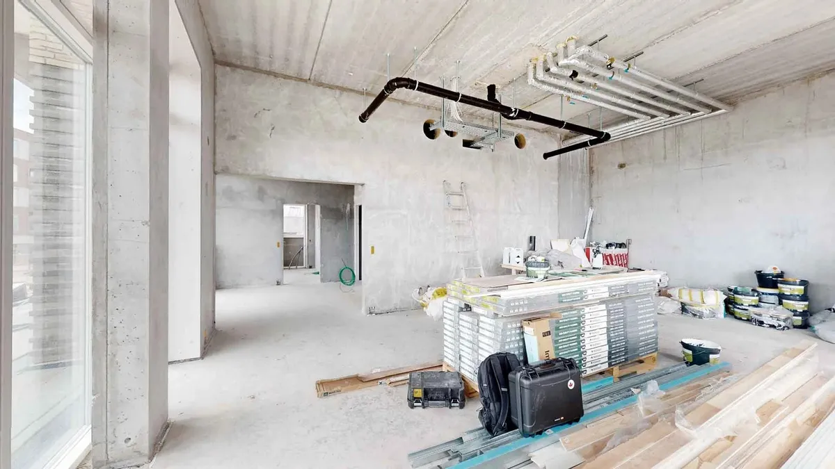 Under et nyrenoveret loft ses værktøj, kasser og to rejsekuffert lægges op på en paller i en renoveret lejlighed