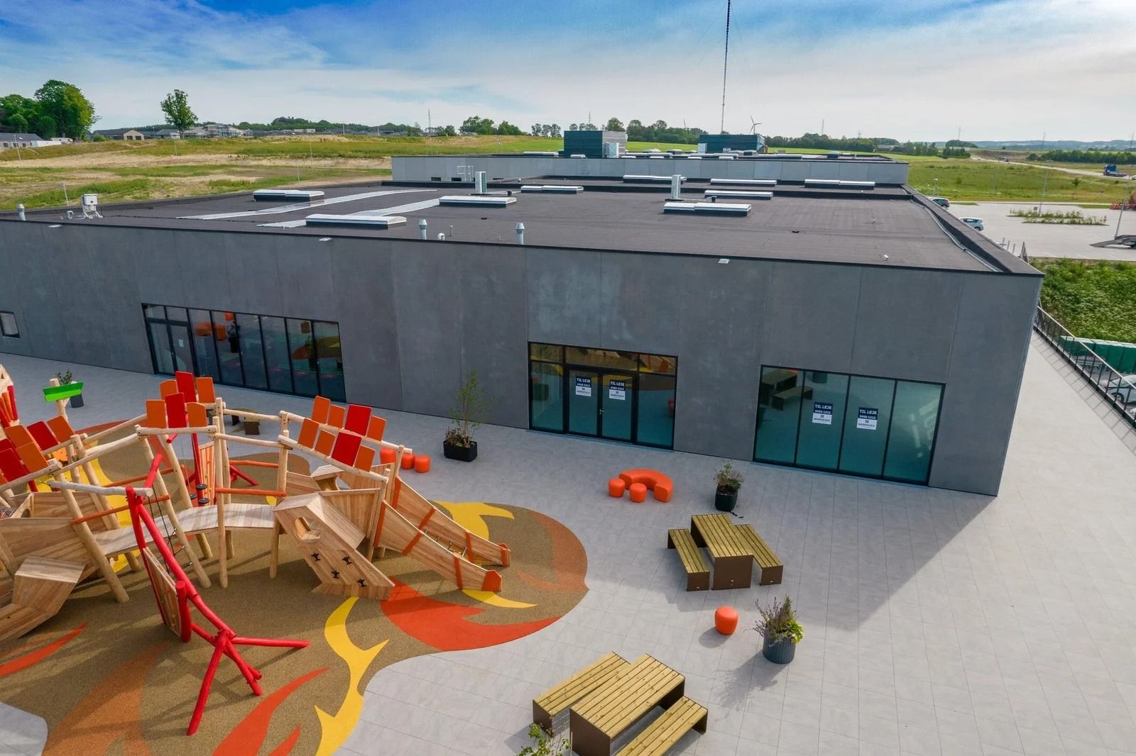 Lejlighedsbygningen med solcellepaneler og legeplads i Næstved Retail Park, med grønne arealer og moderne udseende