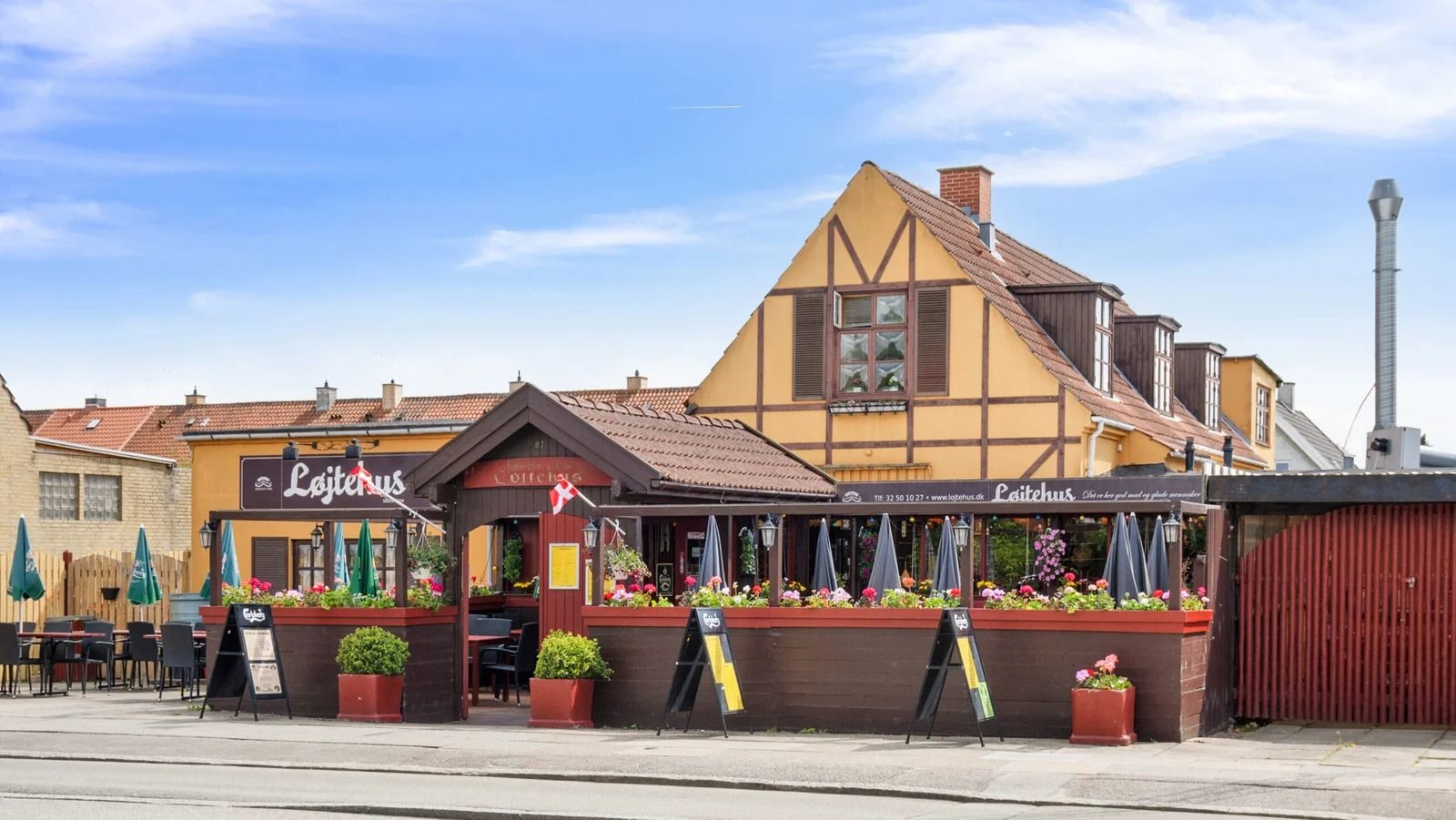 Løjtegårdsvej restaurant med blomster på facaden og solrige skyer i baggrunden