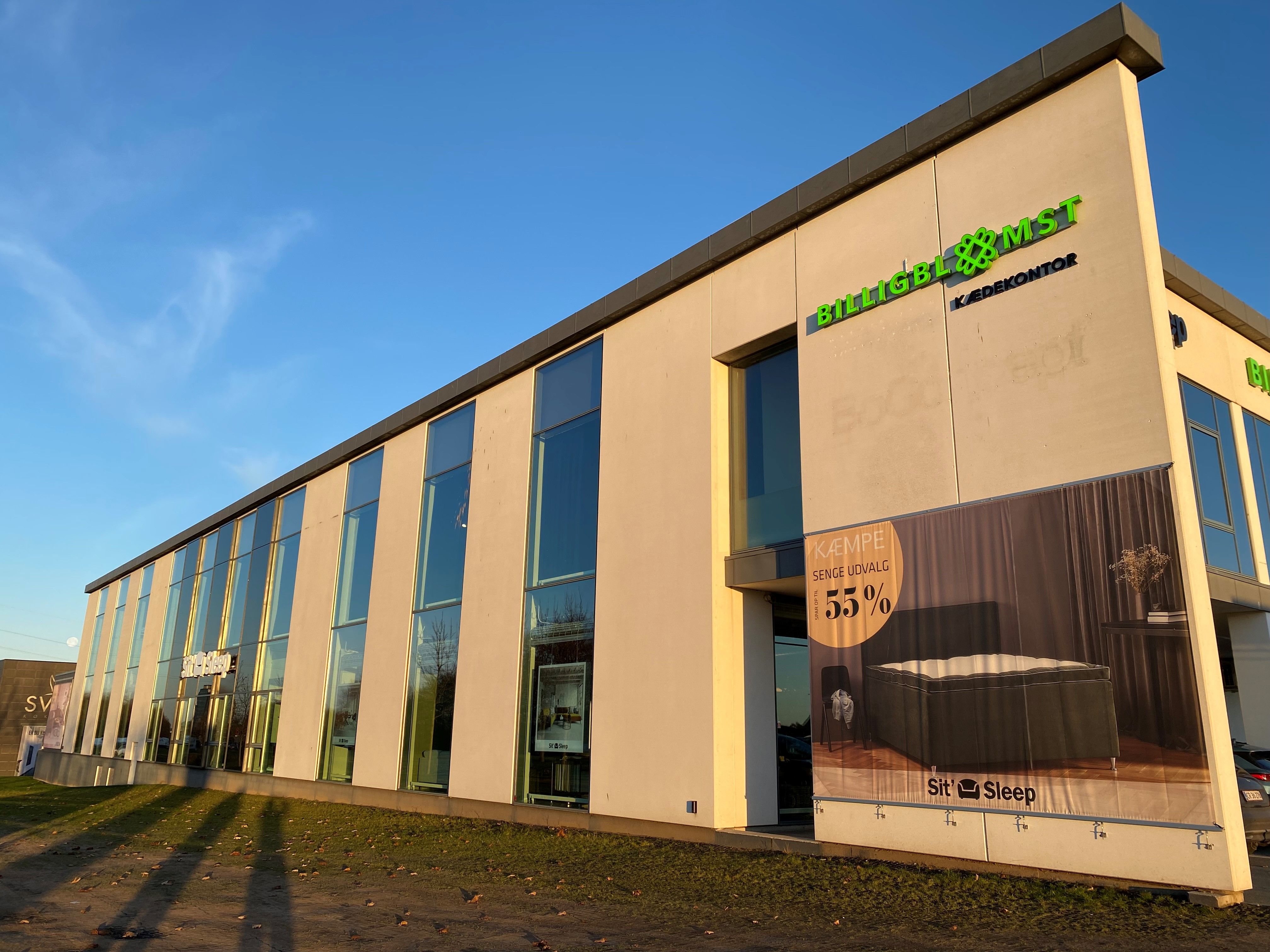 BilligBømst er udbyder af sengetøj, og der er 55% rabat på en enkeltseng og madras. Bygningen har store glasruder og en stor