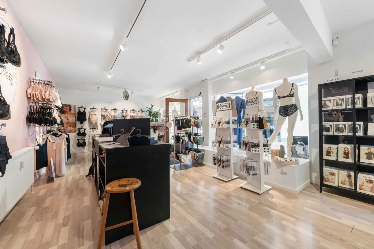 Butik med undertøj og tøj, smukt oplyst og indrettet med hylder, stole og dukker med undertøj