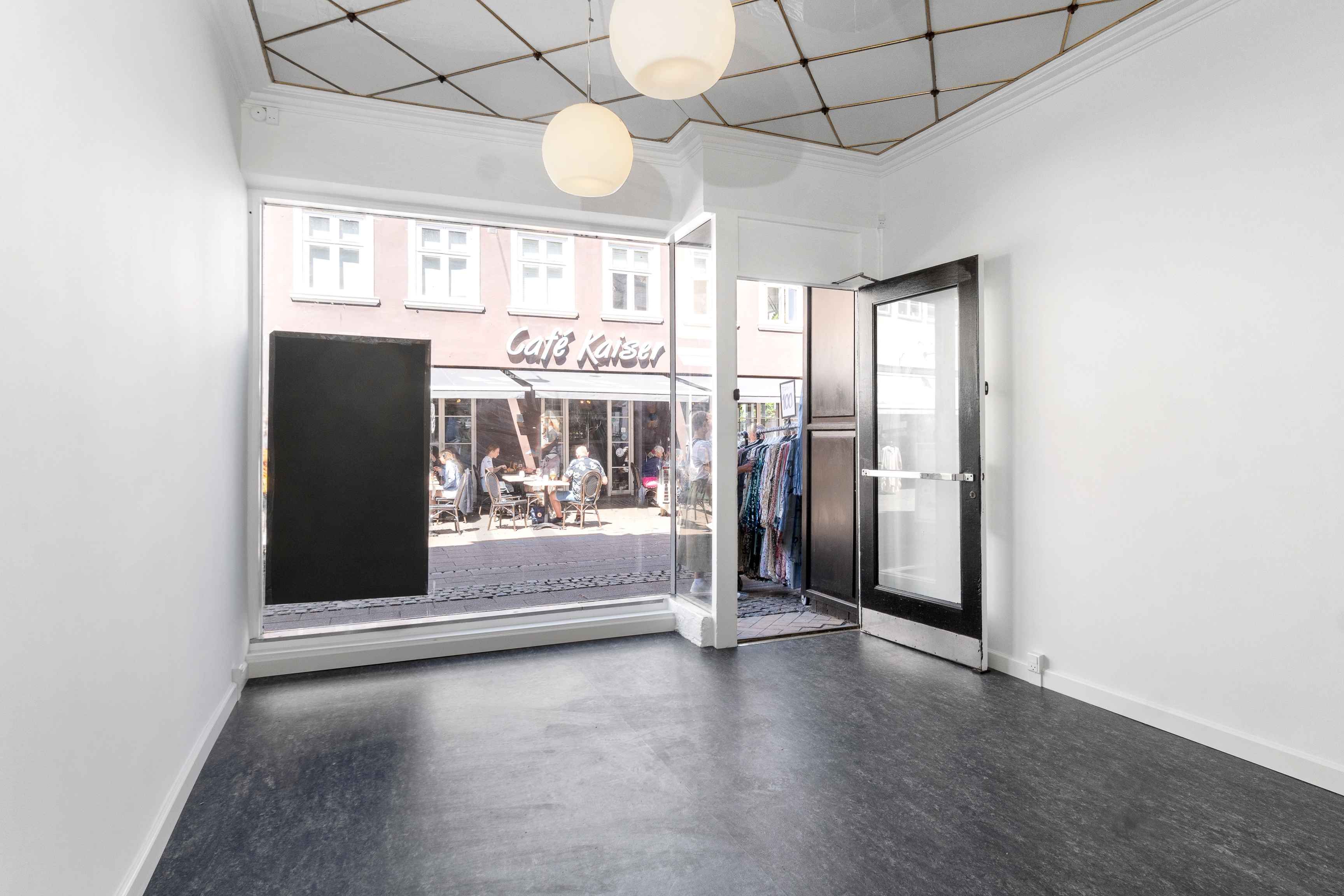 Lejlighed til leje i Helsingør med udsigt til café med terrasse. Værelse med store ruder og lyse gulve. Lukket dør og