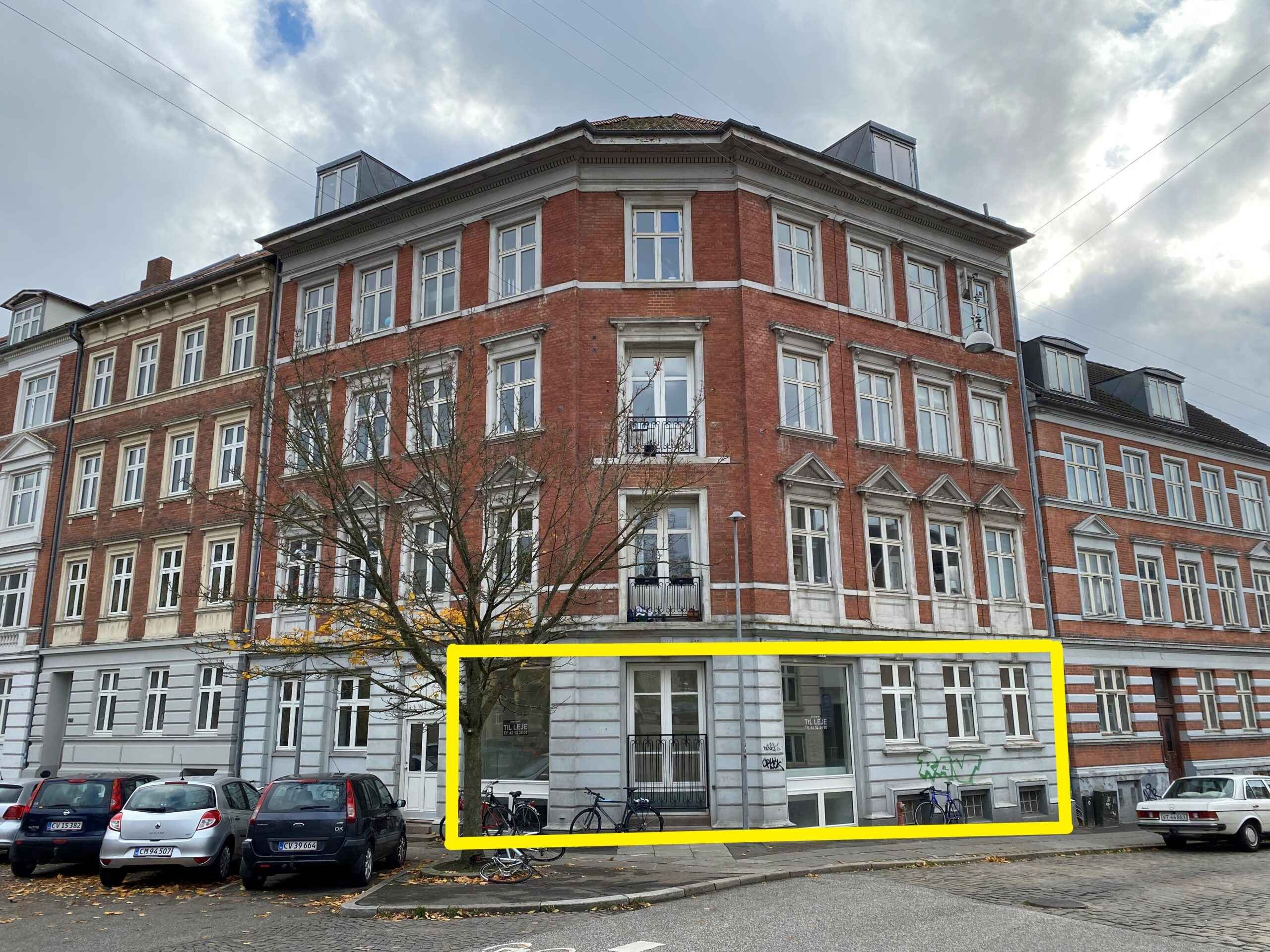 Erhvervslokale i Øgaderne, lige ved Københavns Universitet med store ruder, balkoner og skur, samt parkerede biler og cykler