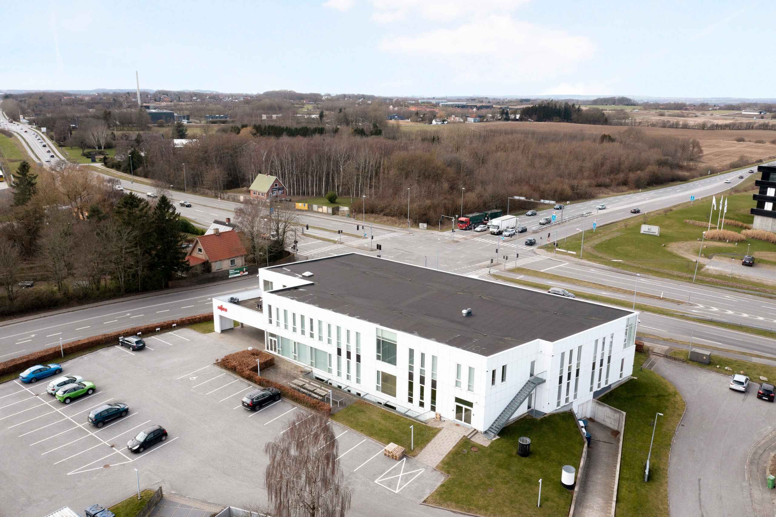 Superflot kontor med stort parkeringsområde. Bygningen er placeret på et velbesøgt område.