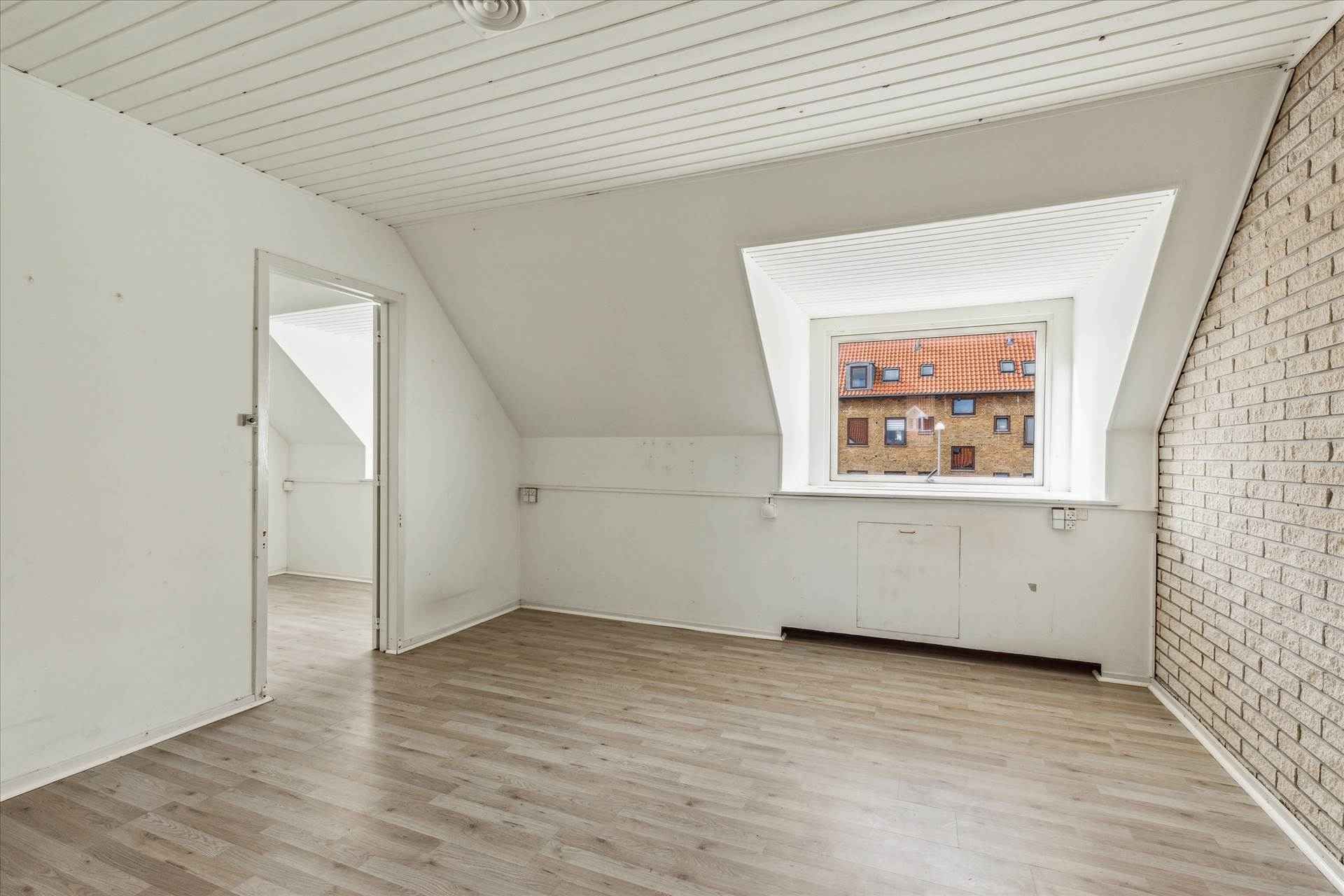 Lukket værelse med hvid væg, hvid loftsbjælke, hvidt loft og hvidt gulv med et vindue med hvidt vindueskarm og en udendørs