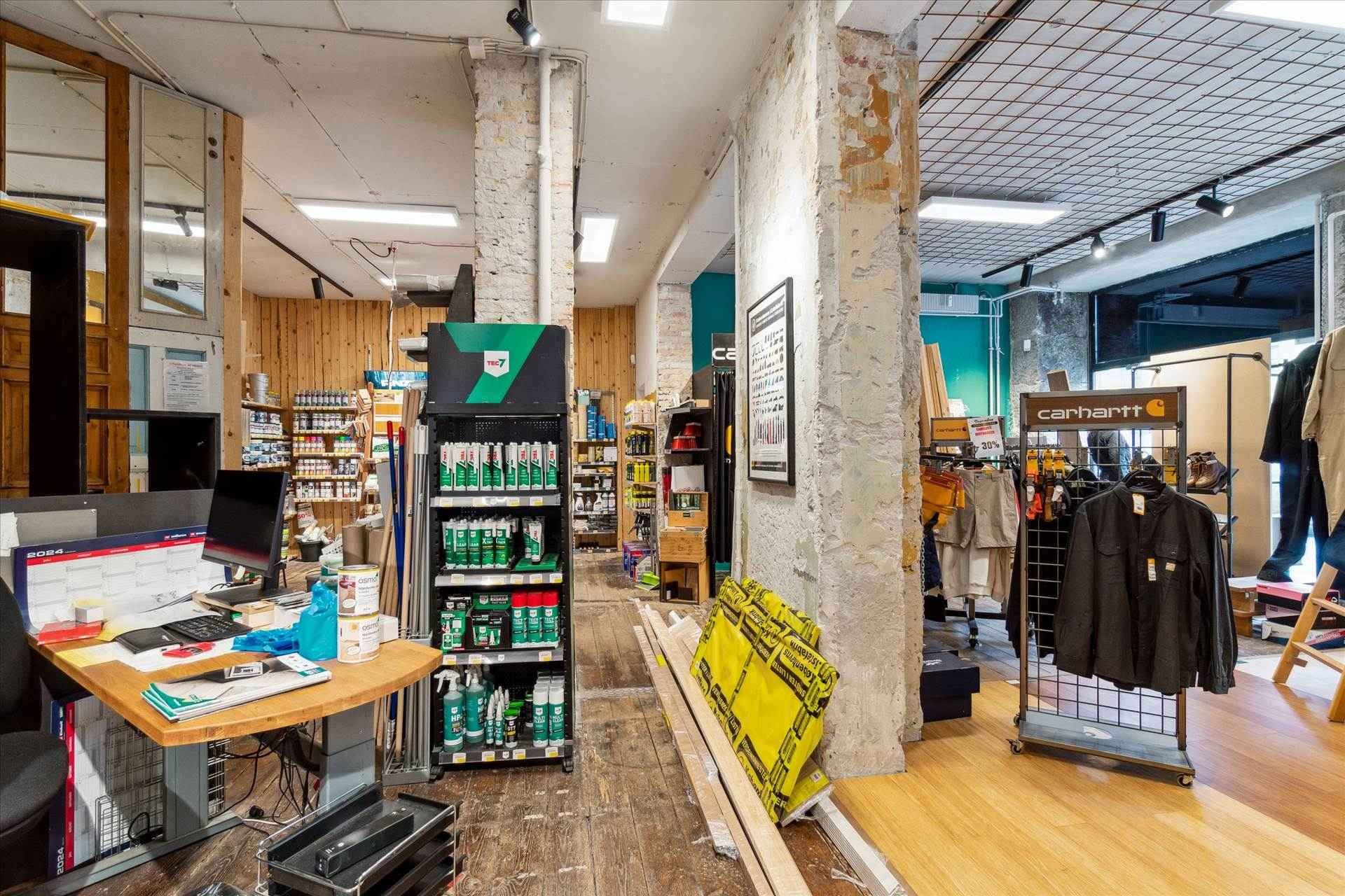 En forretningslokal med salgsstander og lagerreoler, samt en Carhartt-klædeskab med merchandise.