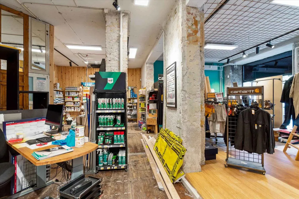 En forretningslokal med salgsstander og lagerreoler, samt en Carhartt-klædeskab med merchandise.