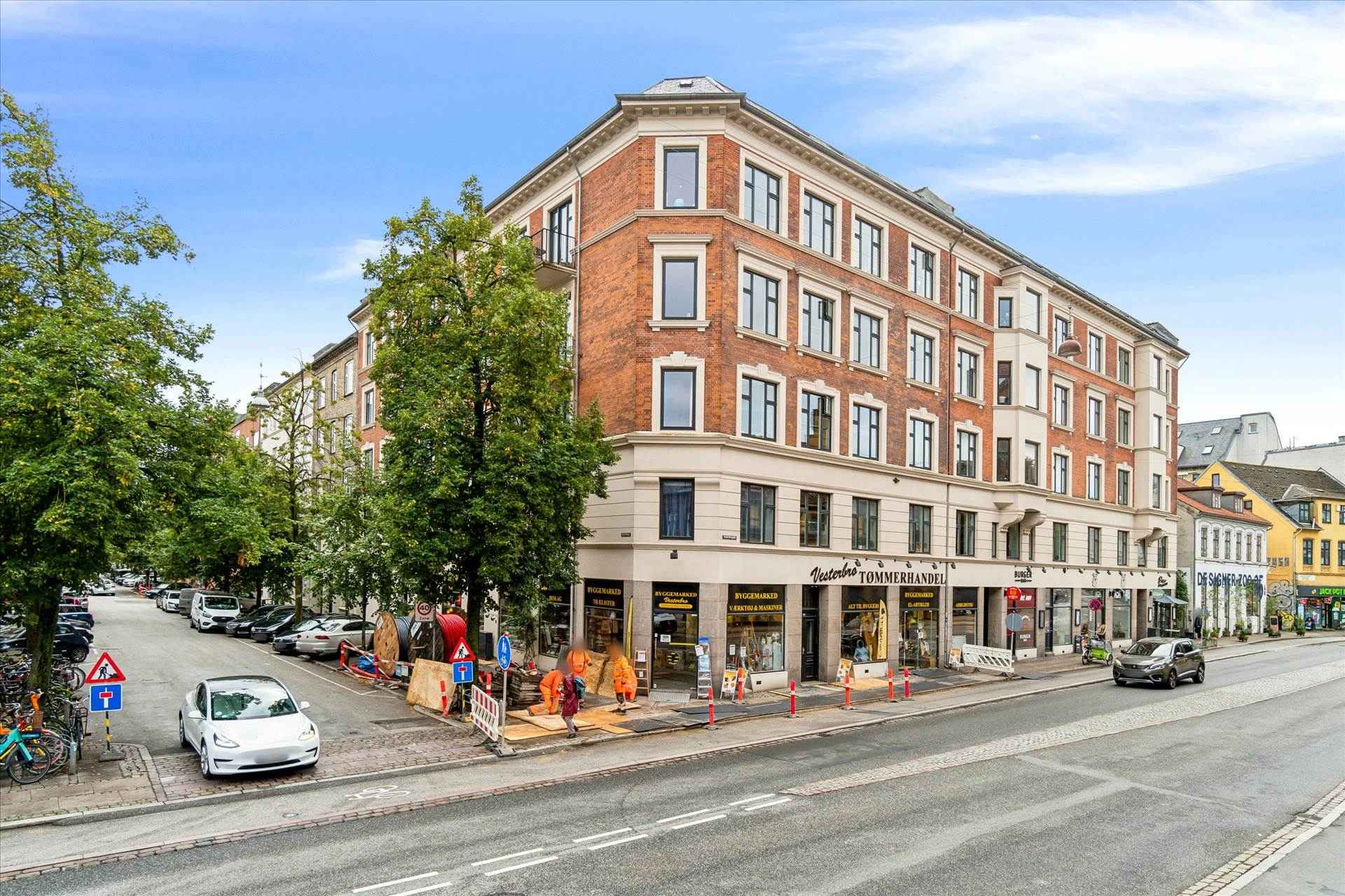 Store erhvervslokaler med stolpenummer 131 på Vesterbrogade og to biler parkeret på siden af gaden