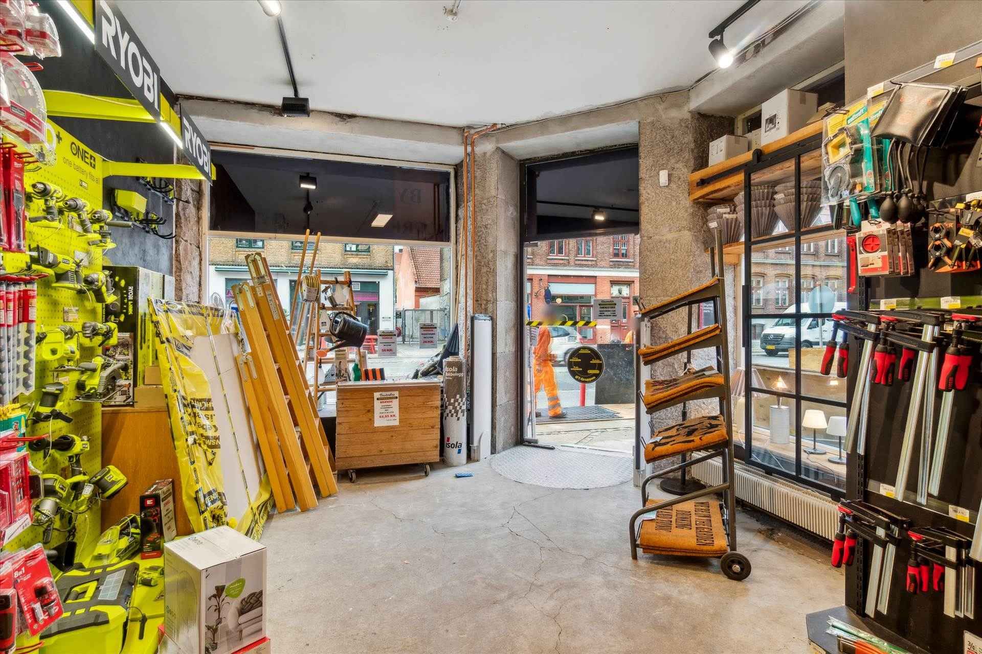 Værksted med værktøj og redskaber, stolpebord og skilte på væggen, en karrusel med redskaber og lager med materialer og