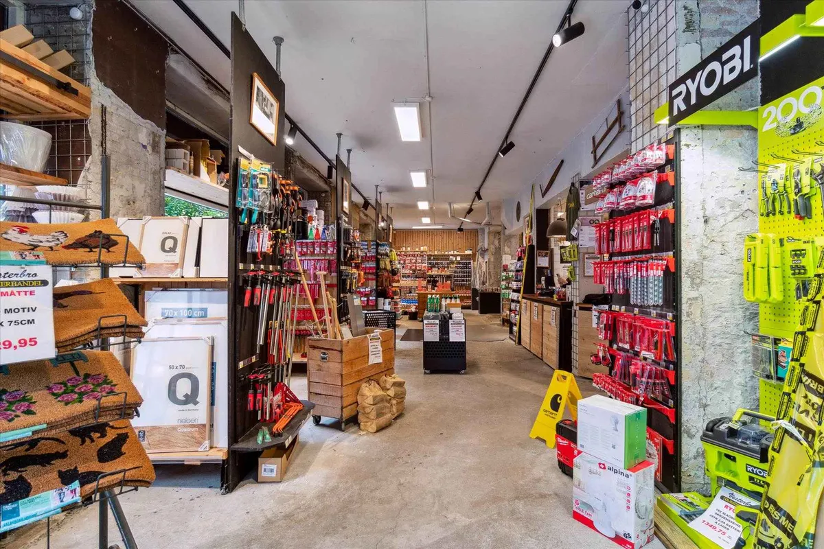 Køkkenhjørne med diverse apparater og værktøj, der er udstillet i en række, og flere produkter er placeret på hylder