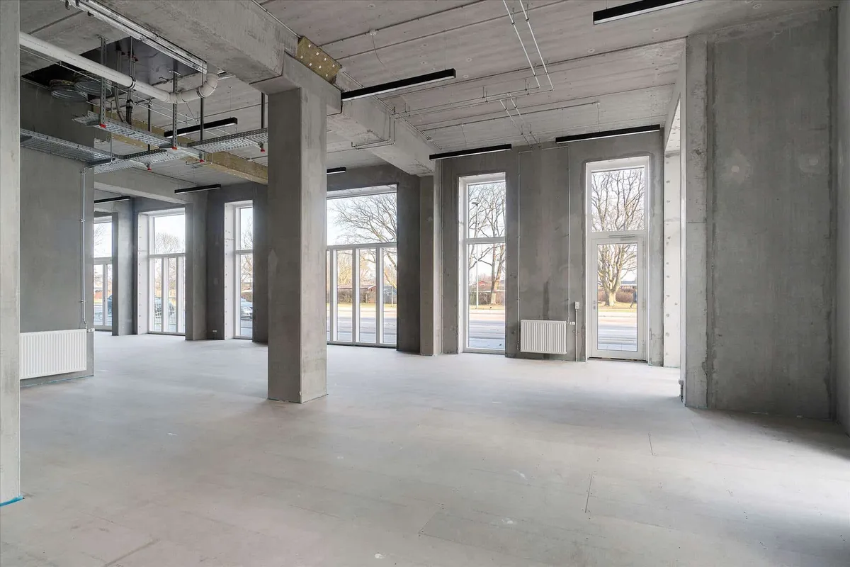 Store erhvervslokaler med store vinduer og cementgulve samt lyse armaturer og højt loft