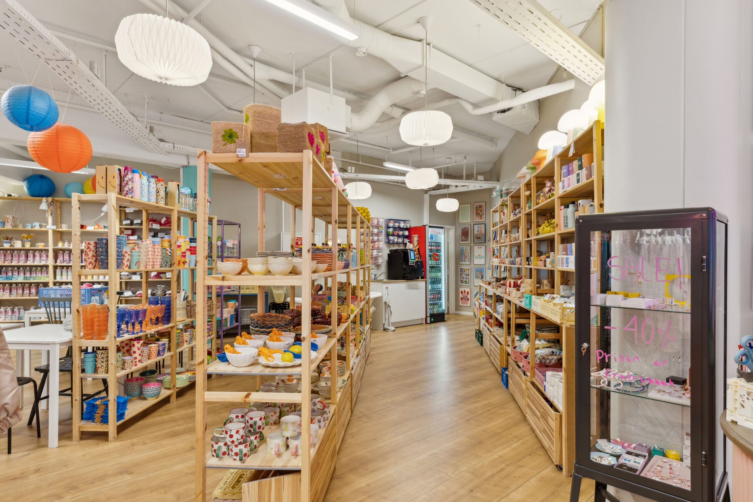 Hjørnelejemål med hyggeligt møbel- og dekorationsforretning med salgetableau og udstillingsskuffer.