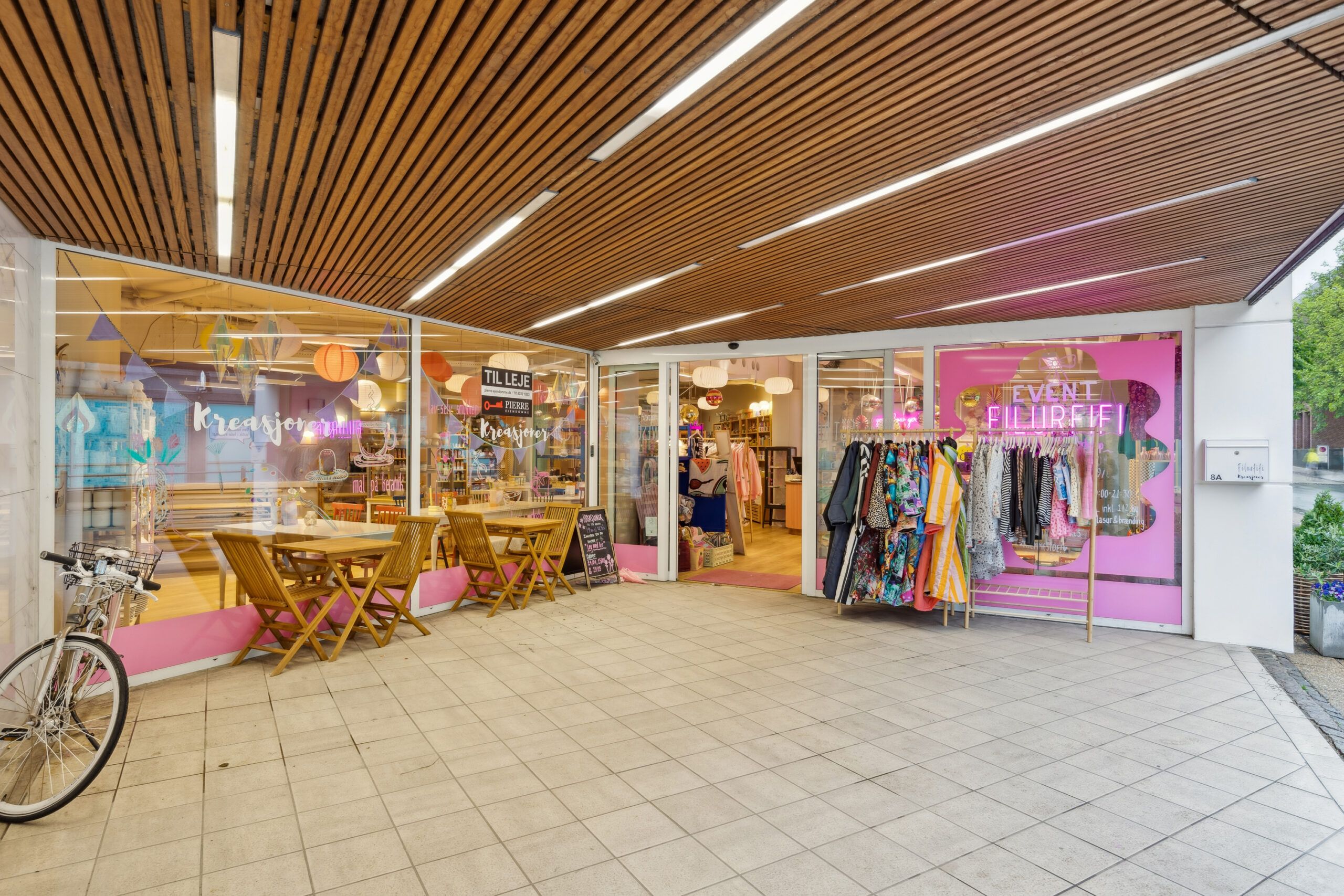 En dejlig butik med møbler og tøj, der er udsmykket med lyse og farverige elementer