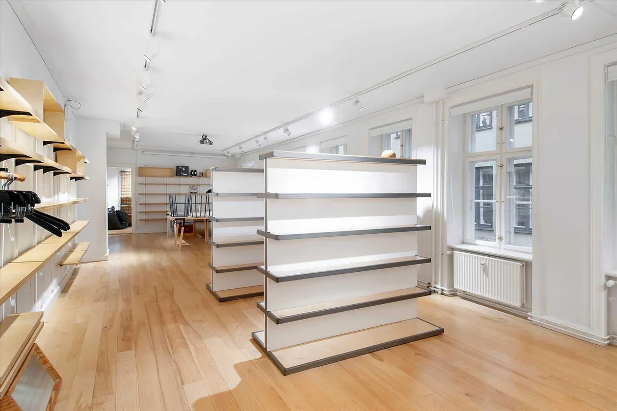 Møbelforretning med højloftede lofter, masser af lys og moderne, hvide møbler, der giver plads til flotte møbelopsætninger.