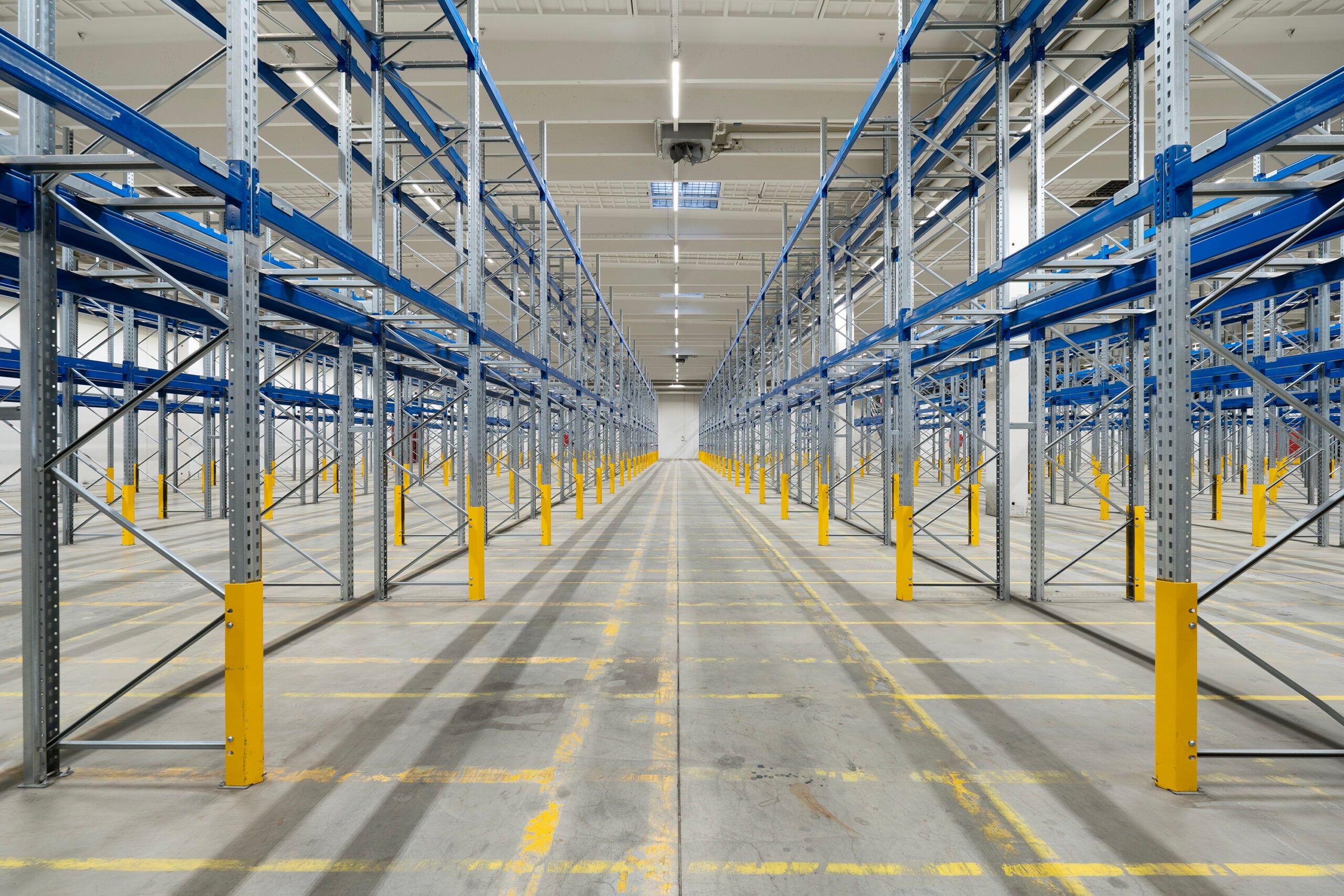 Lager med mønstret gulv og lysegul og blå metalbøjler samt lys og ventiler på loftet