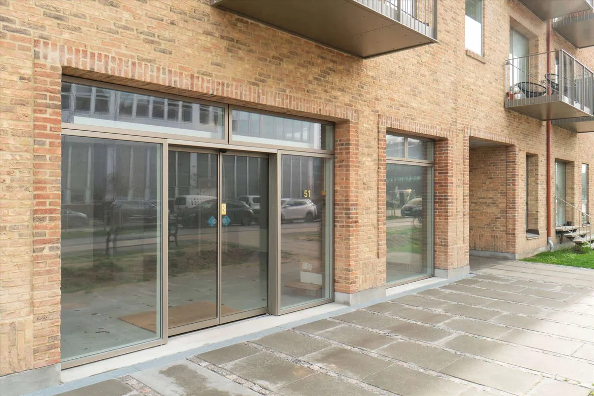 En moderne murstensbygning med store glasruder og store glasdøre, hvor der er opført et nyt erhvervscenter i Sydhavnen
