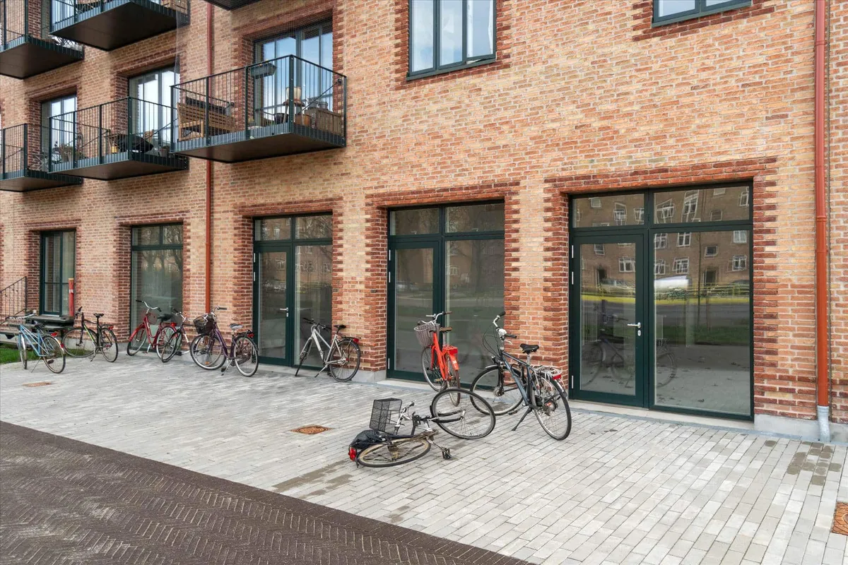 Mange cykler er parkeret foran nye boligher, og en af dem ligger sammenbrudt på jorden