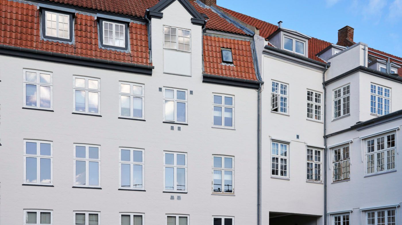 Nyrenoverede huslejligheder med røde tagfliser og glasruder med hvide rammer og skurteløb