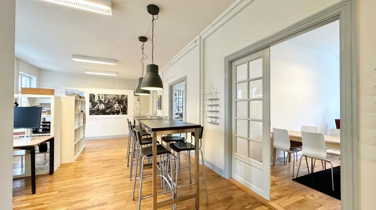 En stor og luksuriøs kontor- eller mødelokale med høje lofter, højt gulv og moderne interiørdesign