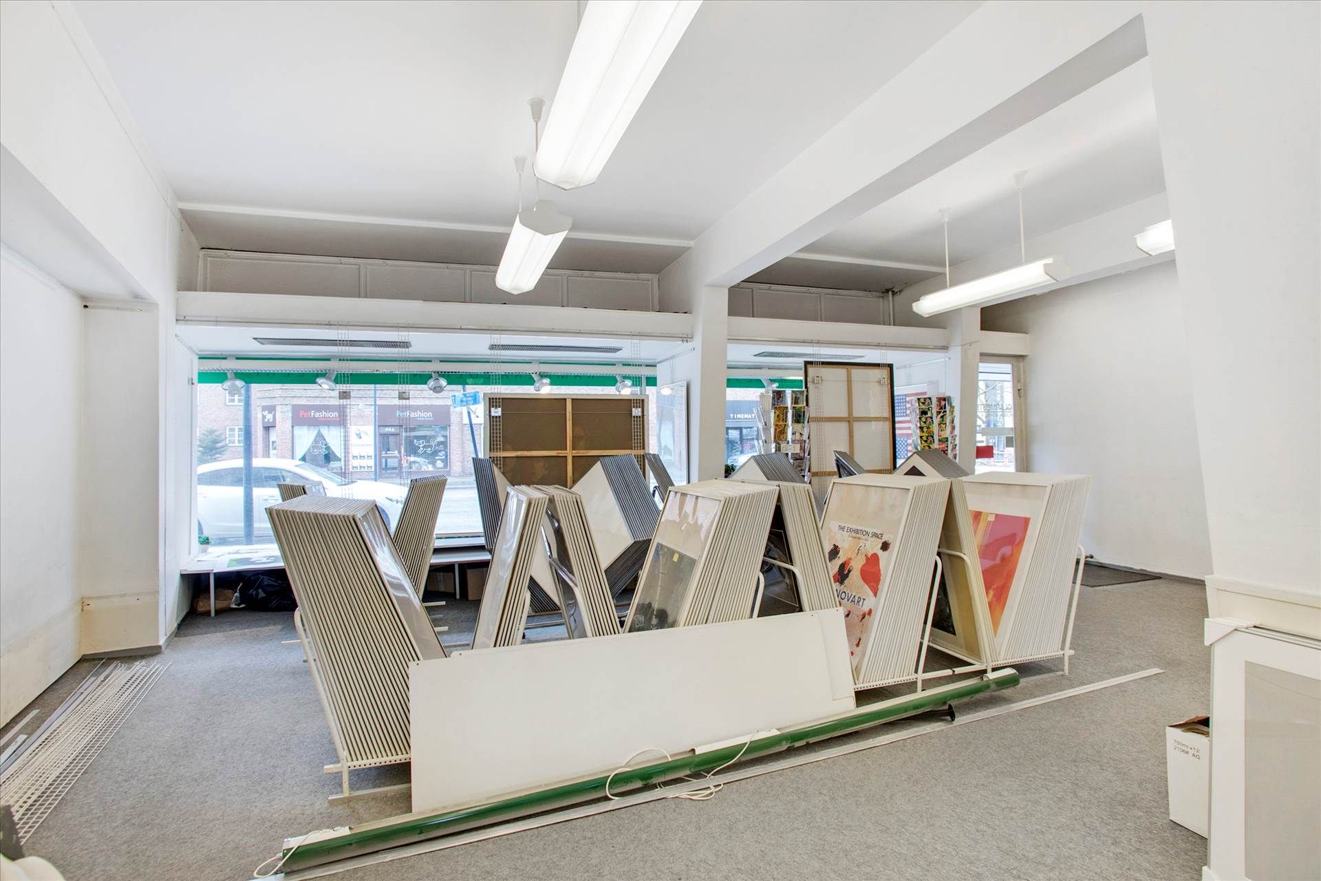 Store rammer og plakater i en tom butikslokal i Kgs. Lyngby med gode facadevinduer og nem indretning.