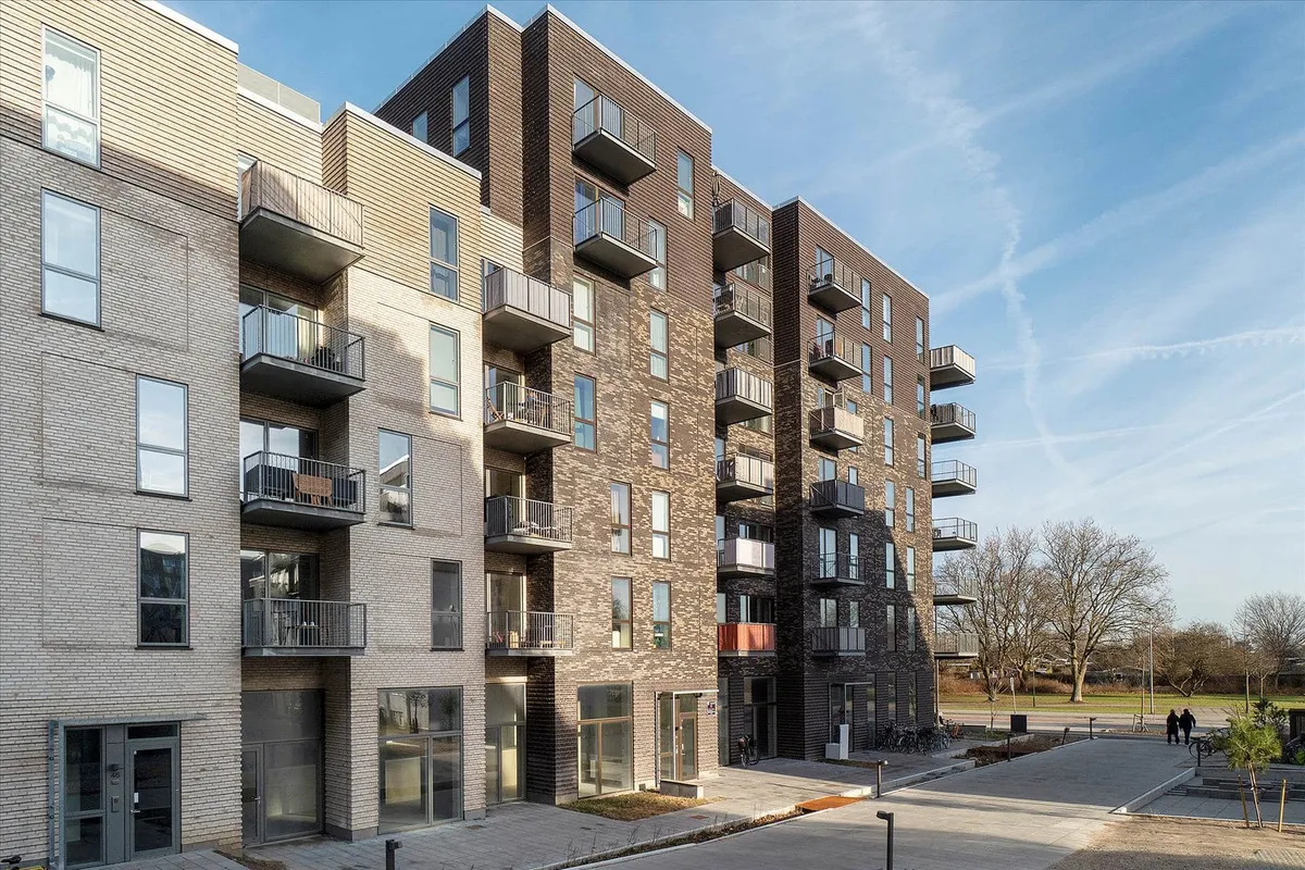 Moderne lejlighedsbyggeri med terrasser og balkoner på Amager Strandvej, med udsigt over parken, solrige huse og smukke