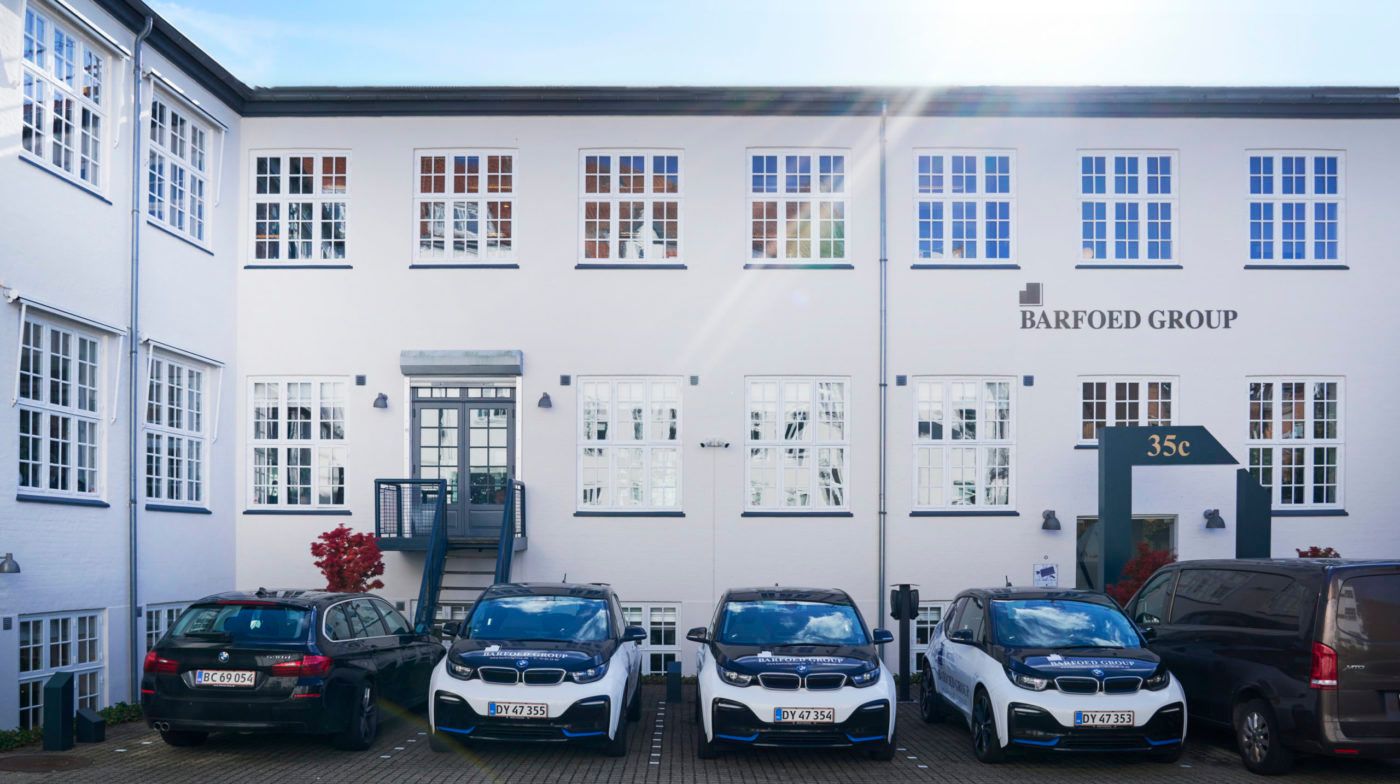 En række BMW i4 elbiler parkeret foran Barfoed Group, der ligger i Nedergade Kvarter