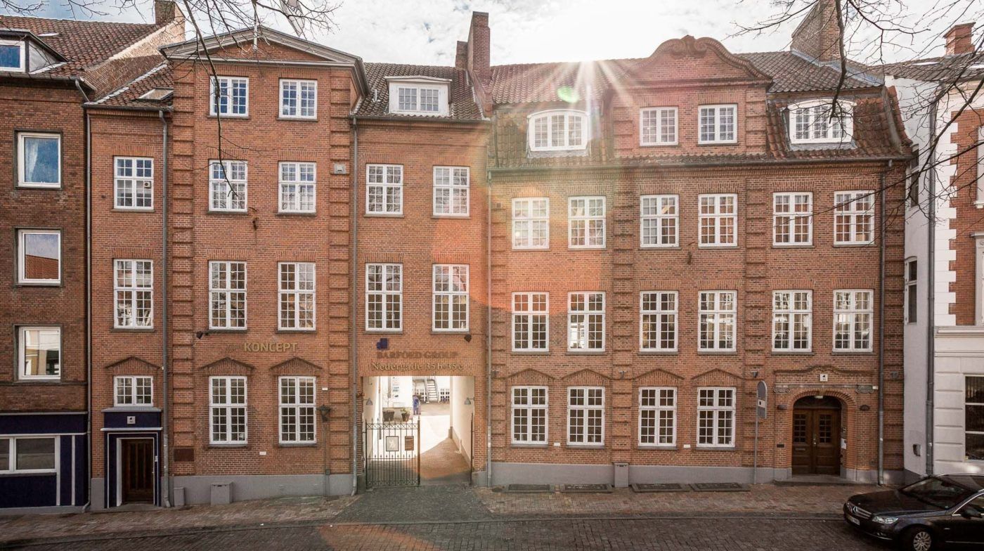 Brystværk i Nedergade 13 med røde mursten og hvide vinduer samt søjler og søjlehoveder