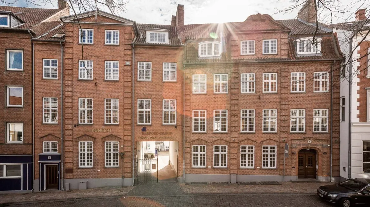 Brystværk i Nedergade 13 med røde mursten og hvide vinduer samt søjler og søjlehoveder