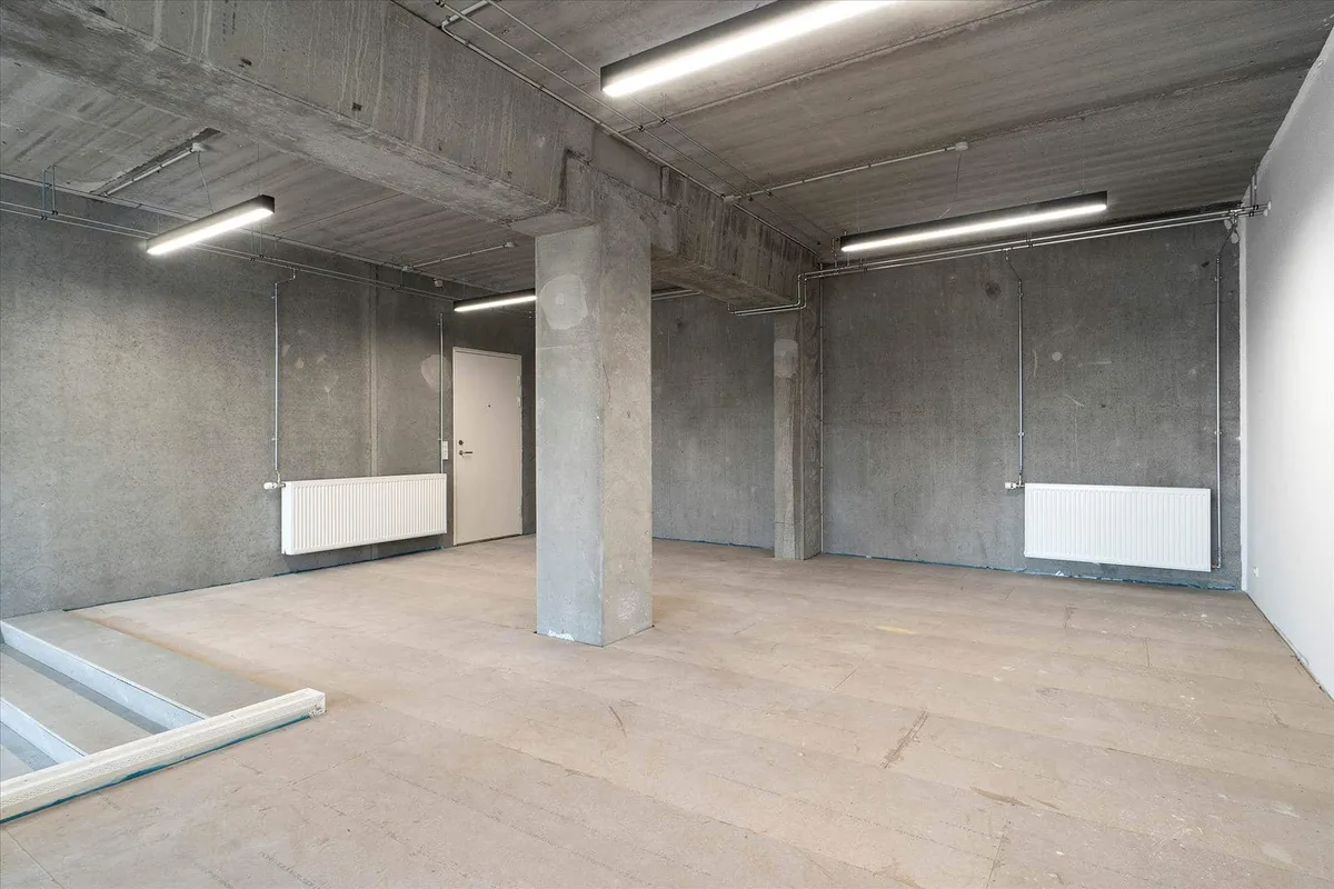 En stor tom erhvervslokal med lyse lofter og masser af naturligt lys, møbler og radiatorer er endnu ikke installeret