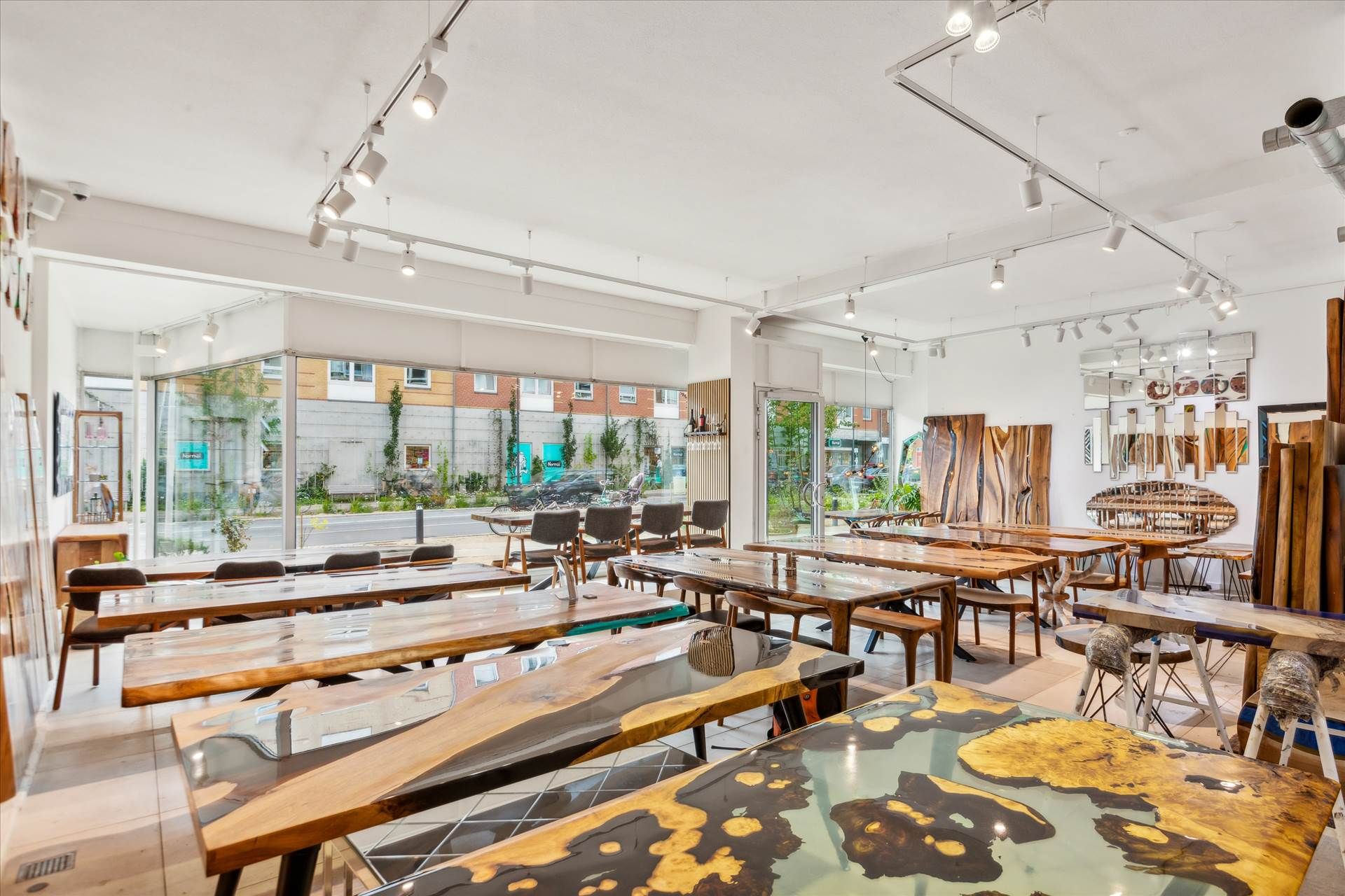 En stor showroom med store træborde og stole samt smukke udsmykninger og lysstofrør på loftet