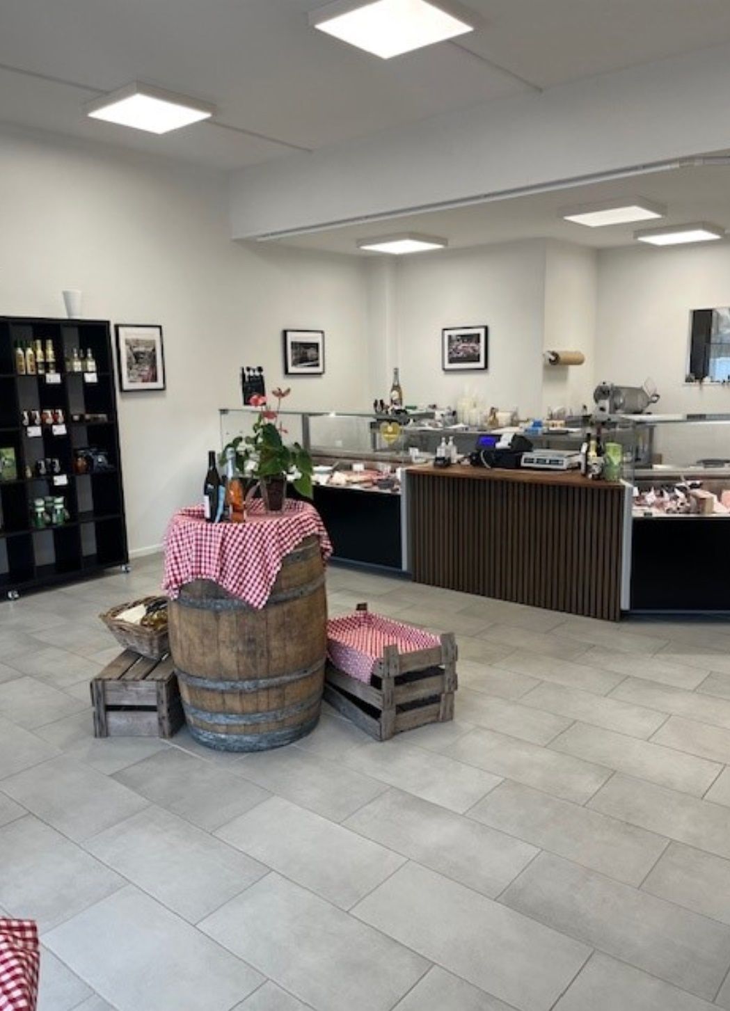 Køkken med trækuffer, plante og rullebord, og et køleskab med flere produkter og ølflasker