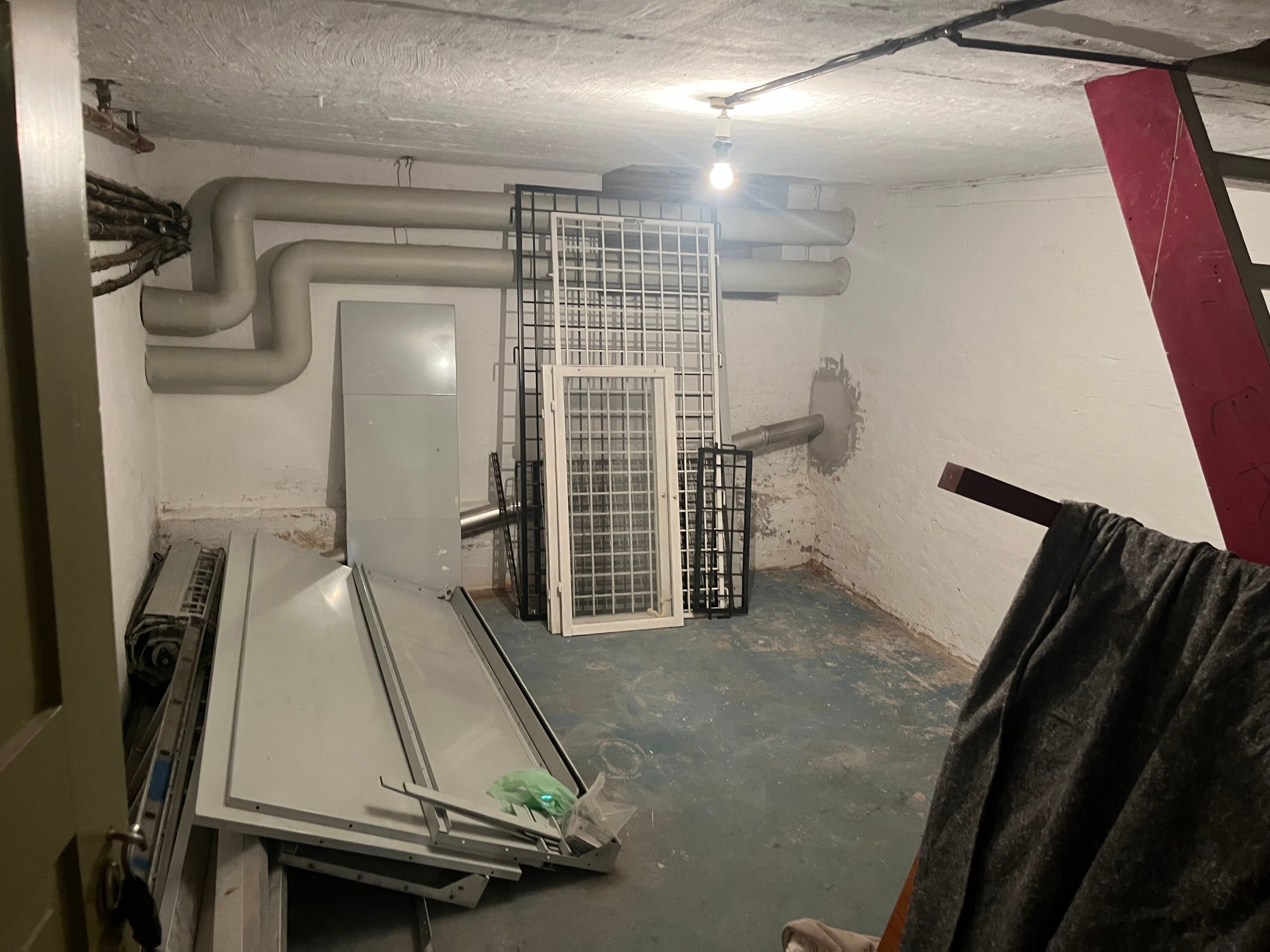 Rum med ventiler og flere hvide metaldøre samt en hængende tørklæde og rødt stål