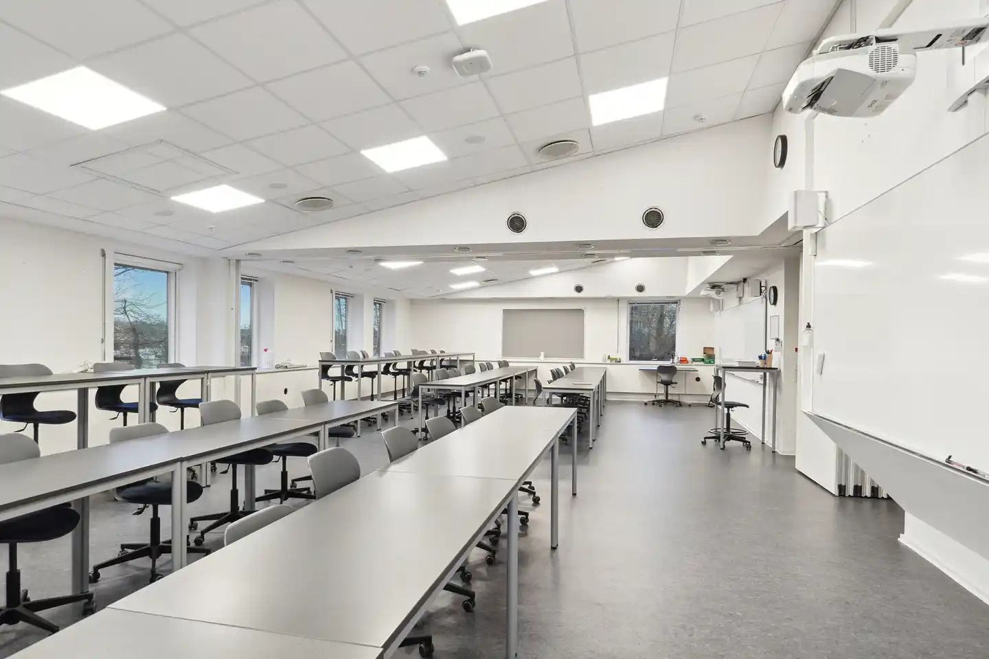 Klassenrum med stolpeborde og høje vinduer, der giver masser af lys og et åbent og moderne klasseværelse