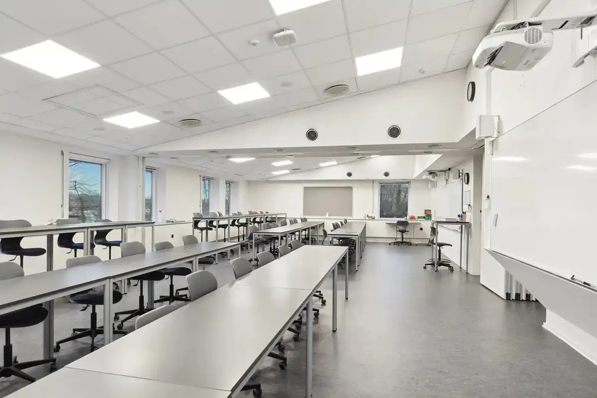 Klassenrum med stolpeborde og høje vinduer, der giver masser af lys og et åbent og moderne klasseværelse