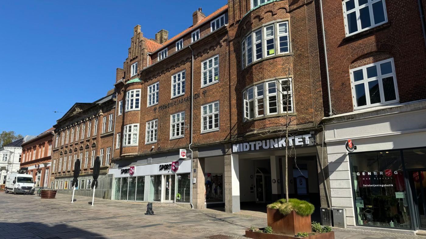 Butikslokaler med udsigt til gaden i Fredericia. Butikkerne er lukket og der er ingen mennesker synlige.