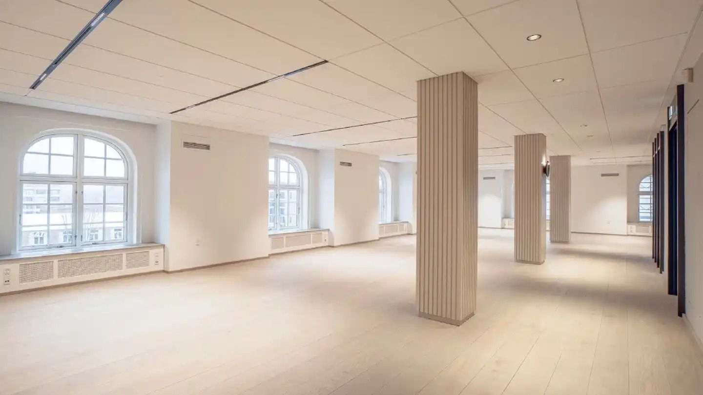 Store lokaler med højt loft, lyse gulve, lysevinduer og to store søjler for at støtte loftet