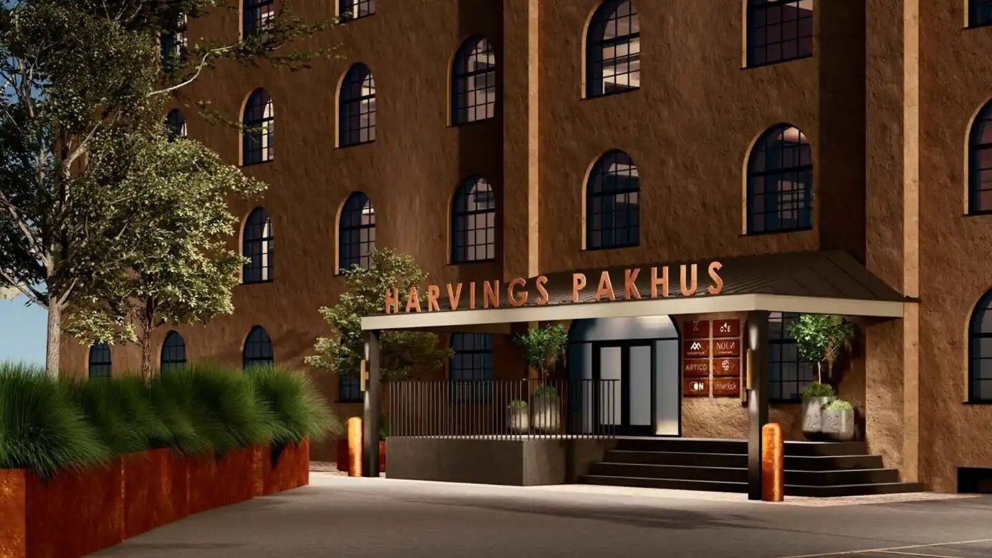 Harvins Pakhus er et kontorlokal med lyse gulve og møbler og to små planter i jord. Arkitektur med mange runde vinduer og